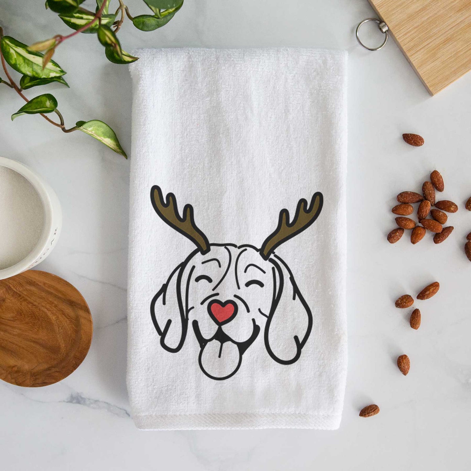 Minimalist line drawing of a Beagle with reindeer antlers and a red nose on a decorative hand towel