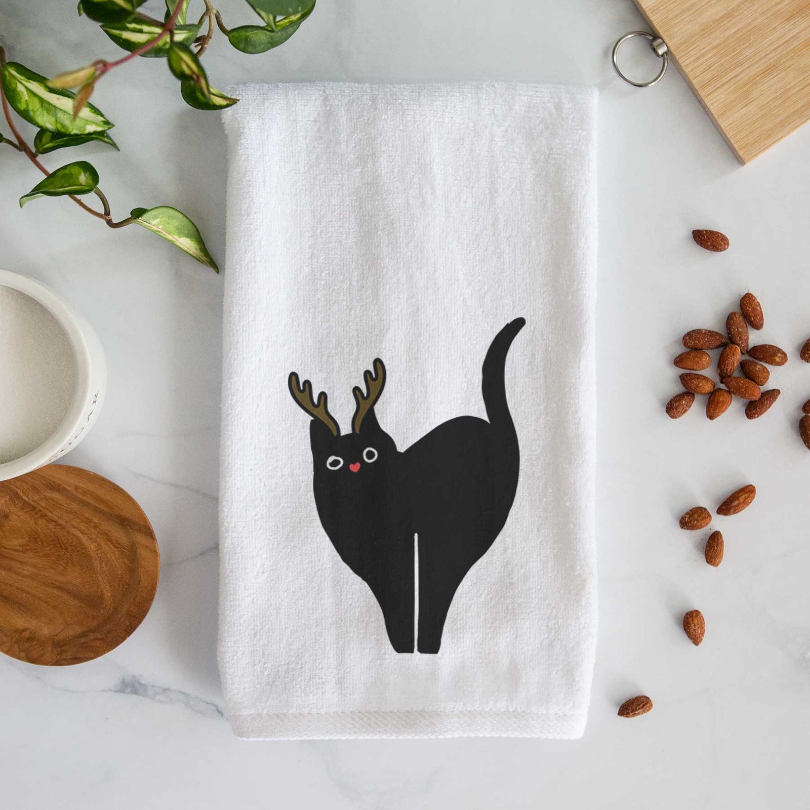 Minimalist line drawing of Bella the Black Cat with reindeer antlers and a red nose on a decorative hand towel