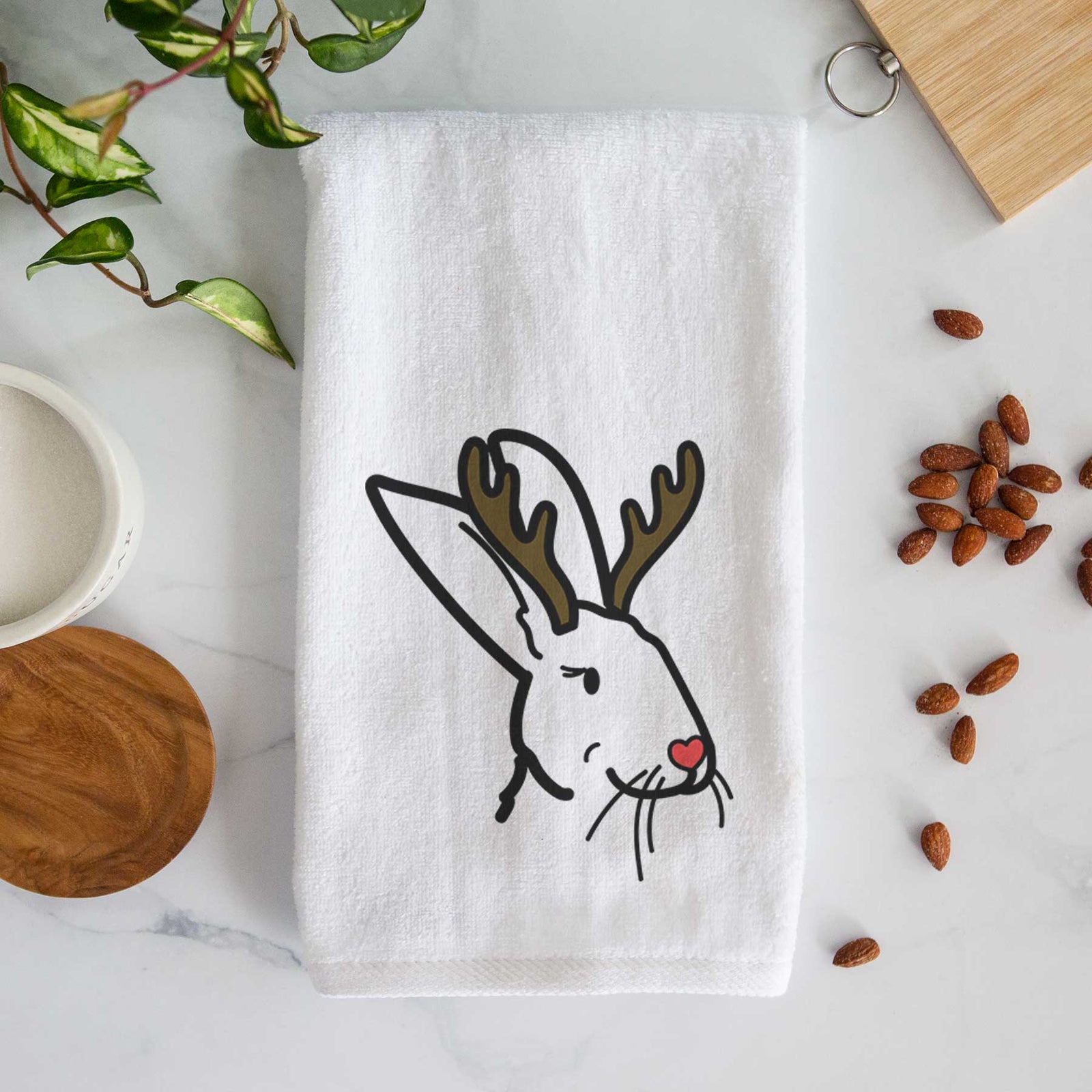 Minimalist line drawing of Betsy the Rex Rabbit with reindeer antlers and a red nose on a decorative hand towel