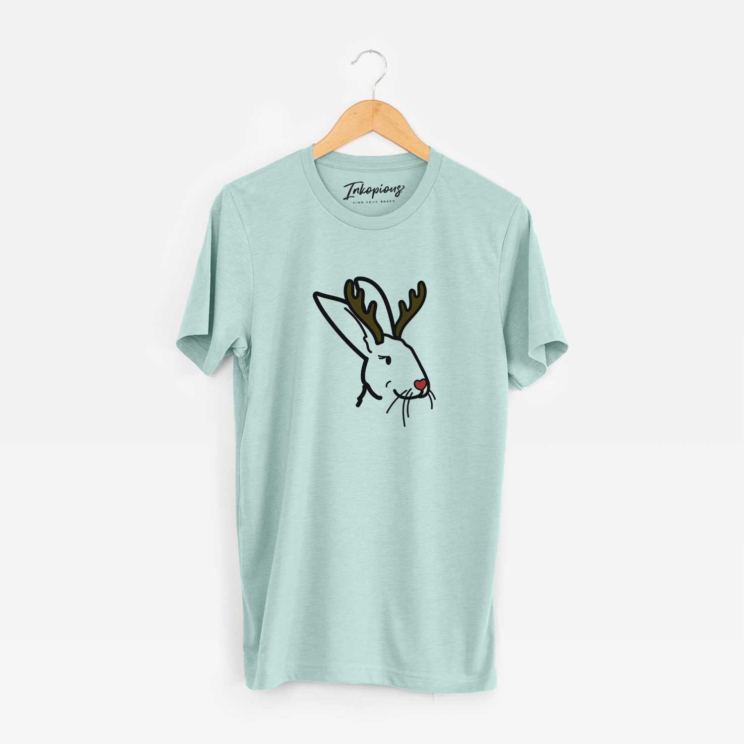 Minimalist line drawing of Betsy the Rex Rabbit with reindeer antlers and a red nose on a Heather Sage Unisex crewneck