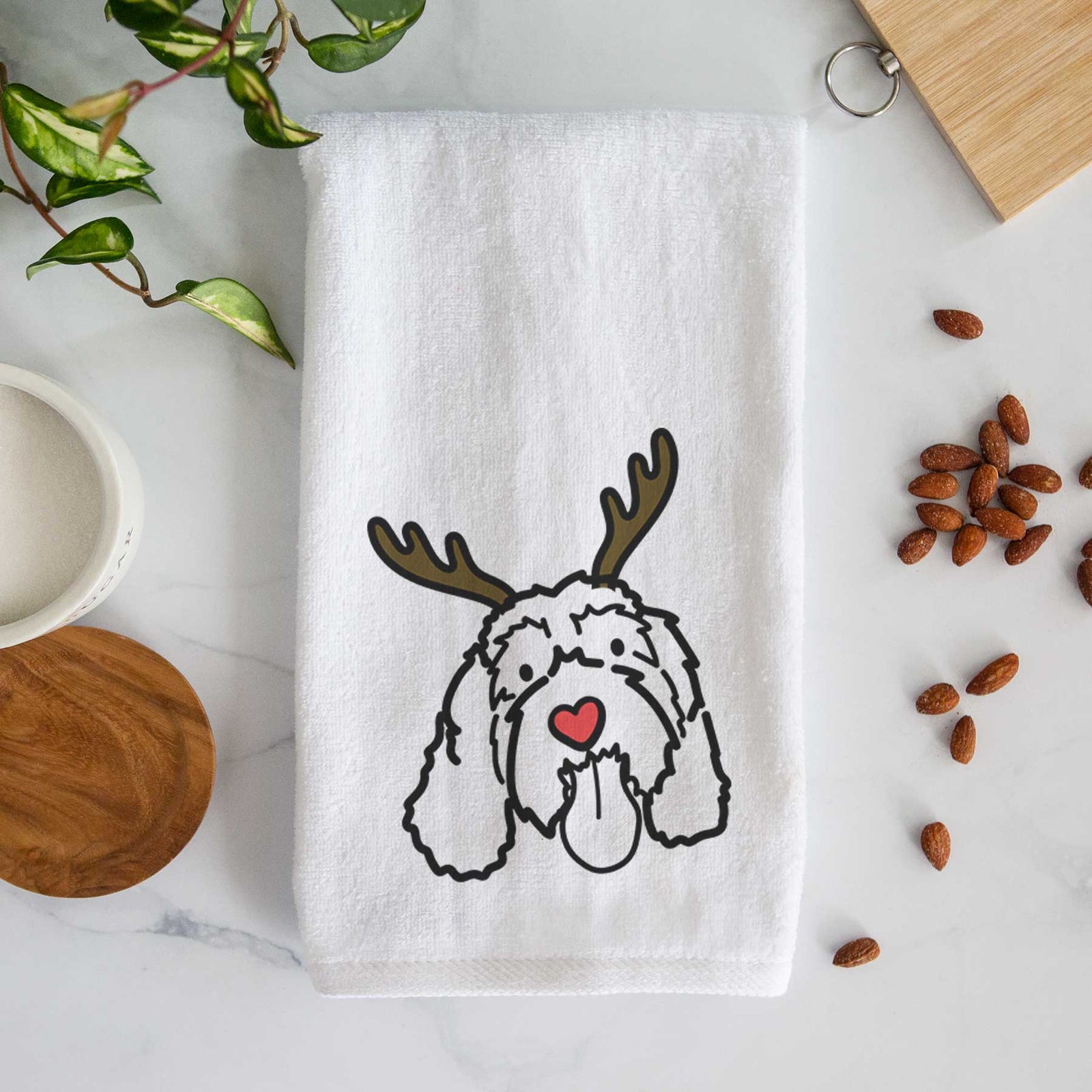 Minimalist line drawing of Bo the Portguese Water Dog with reindeer antlers and a red nose on a decorative hand towel