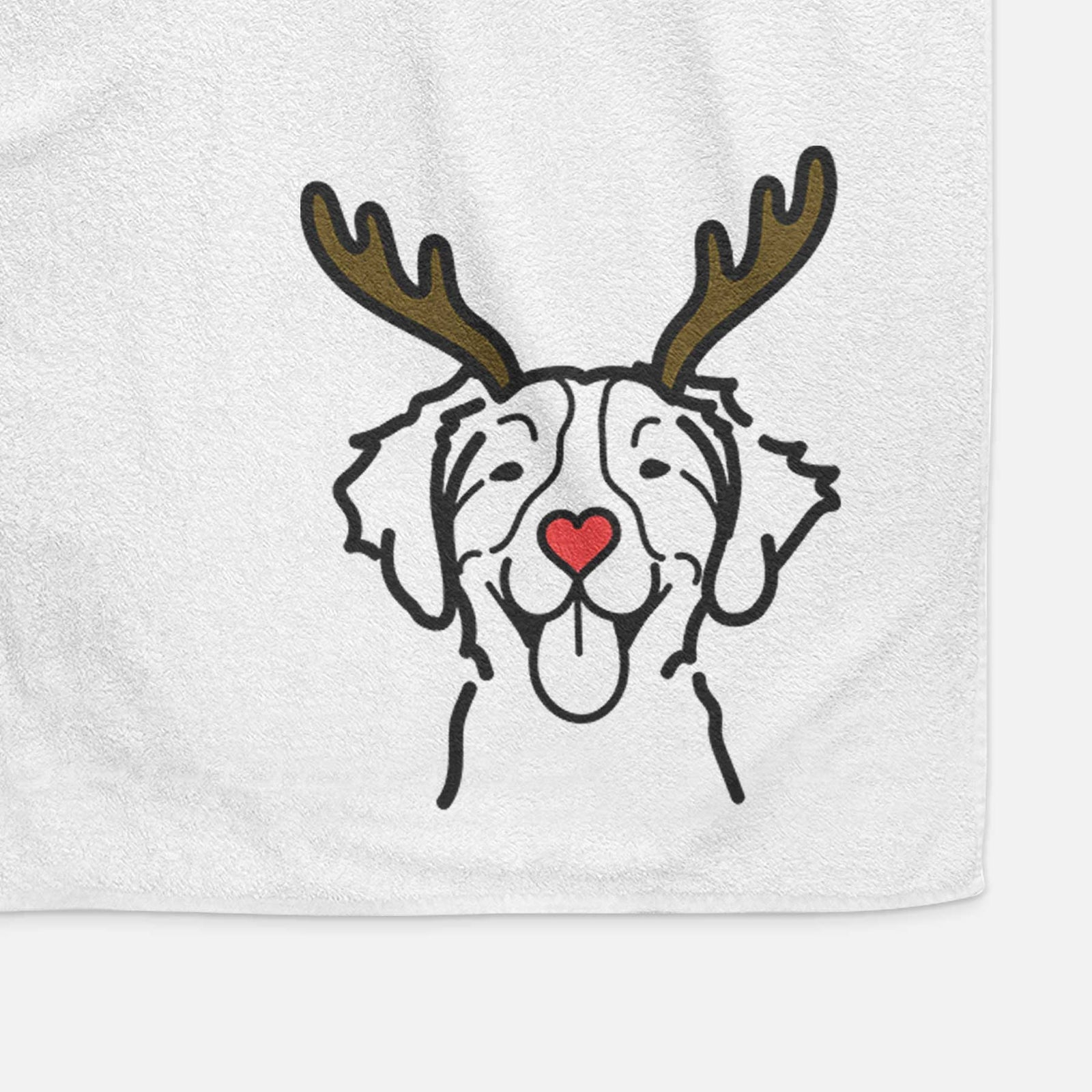 Minimalist line drawing of a Brittany with reindeer antlers and a red nose on a decorative hand towel
