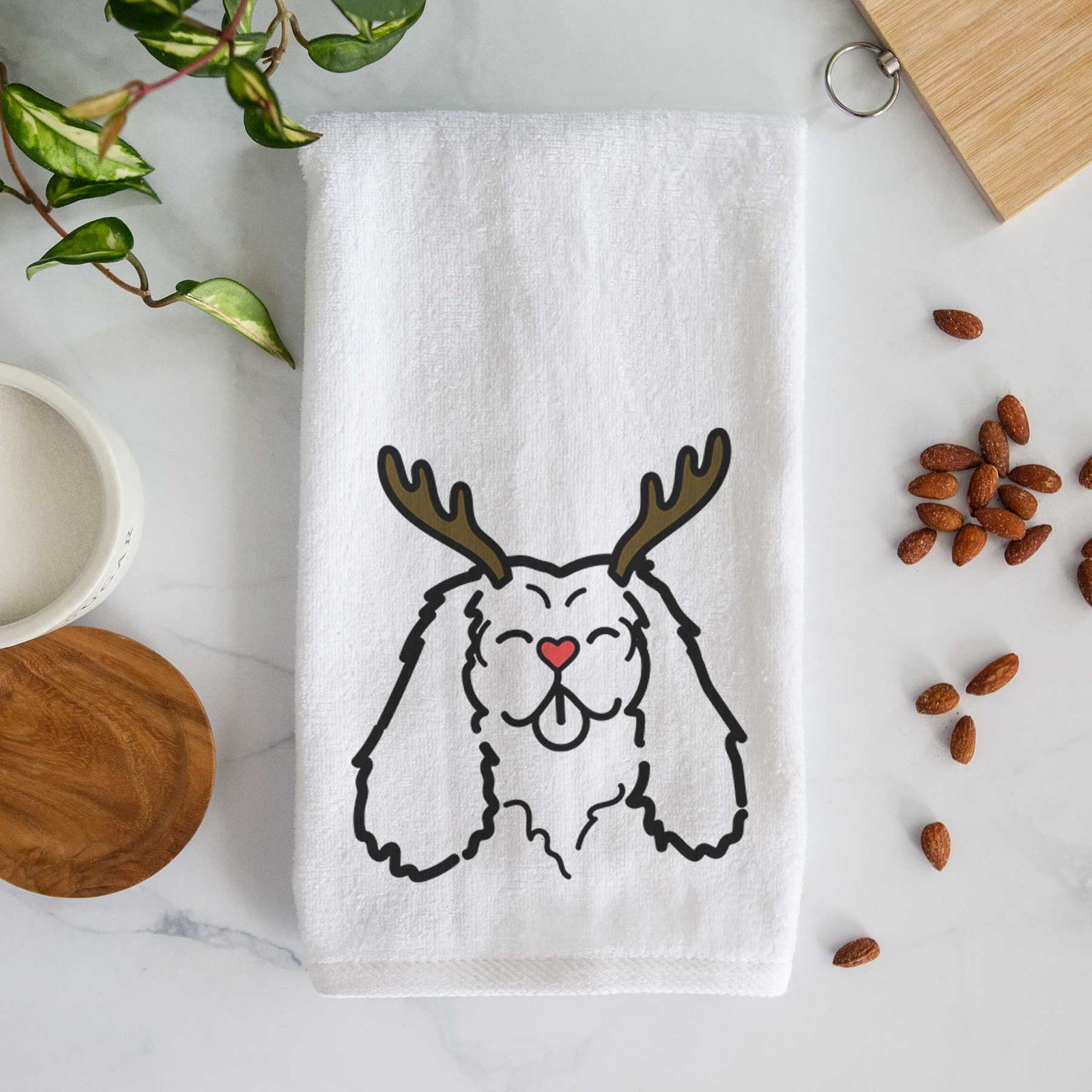 Minimalist line drawing of a Cavalier King Charles Spaniel with reindeer antlers and a red nose on a decorative hand towel