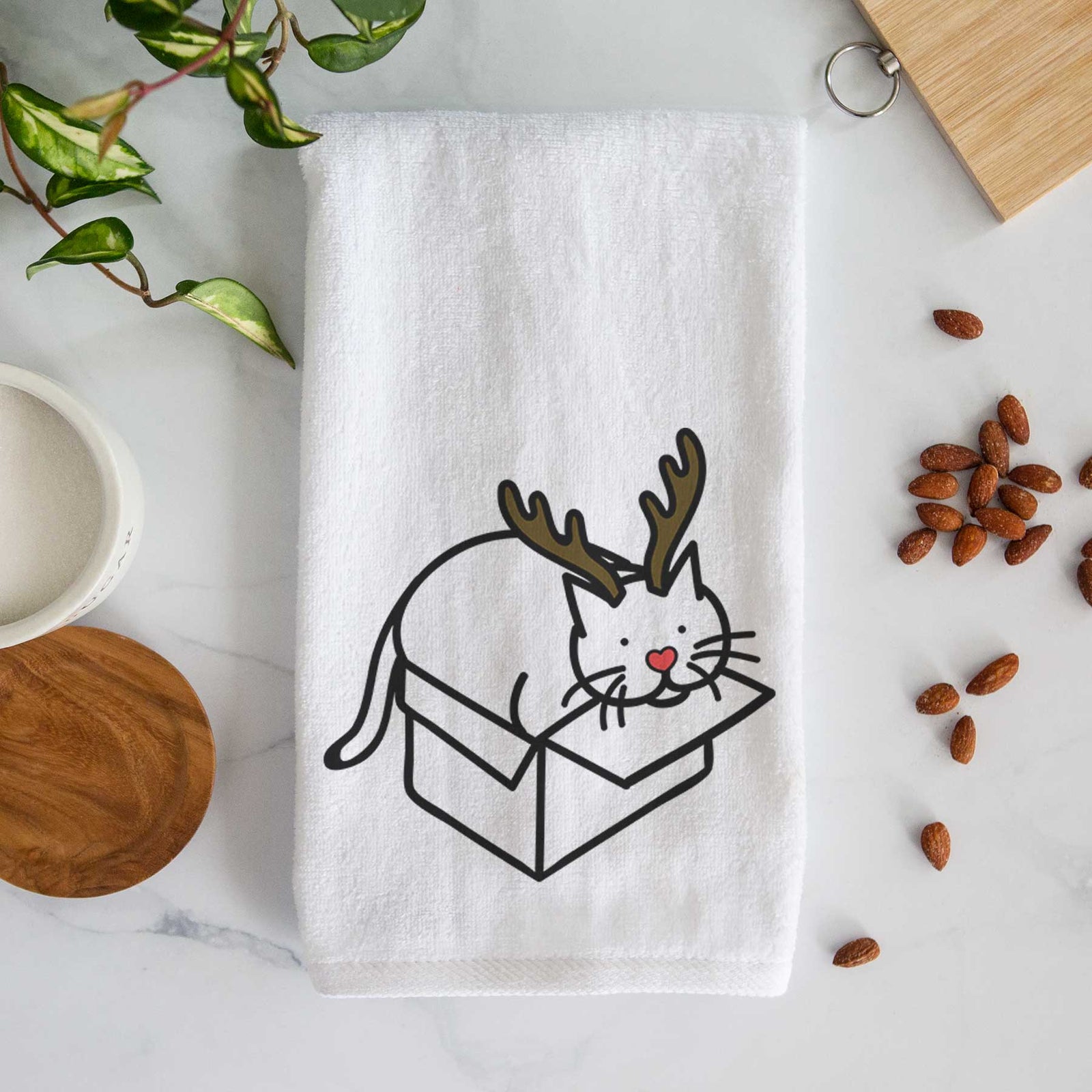 Minimalist line drawing of Charlie the Cat in a Box with reindeer antlers and a red nose on a decorative hand towel