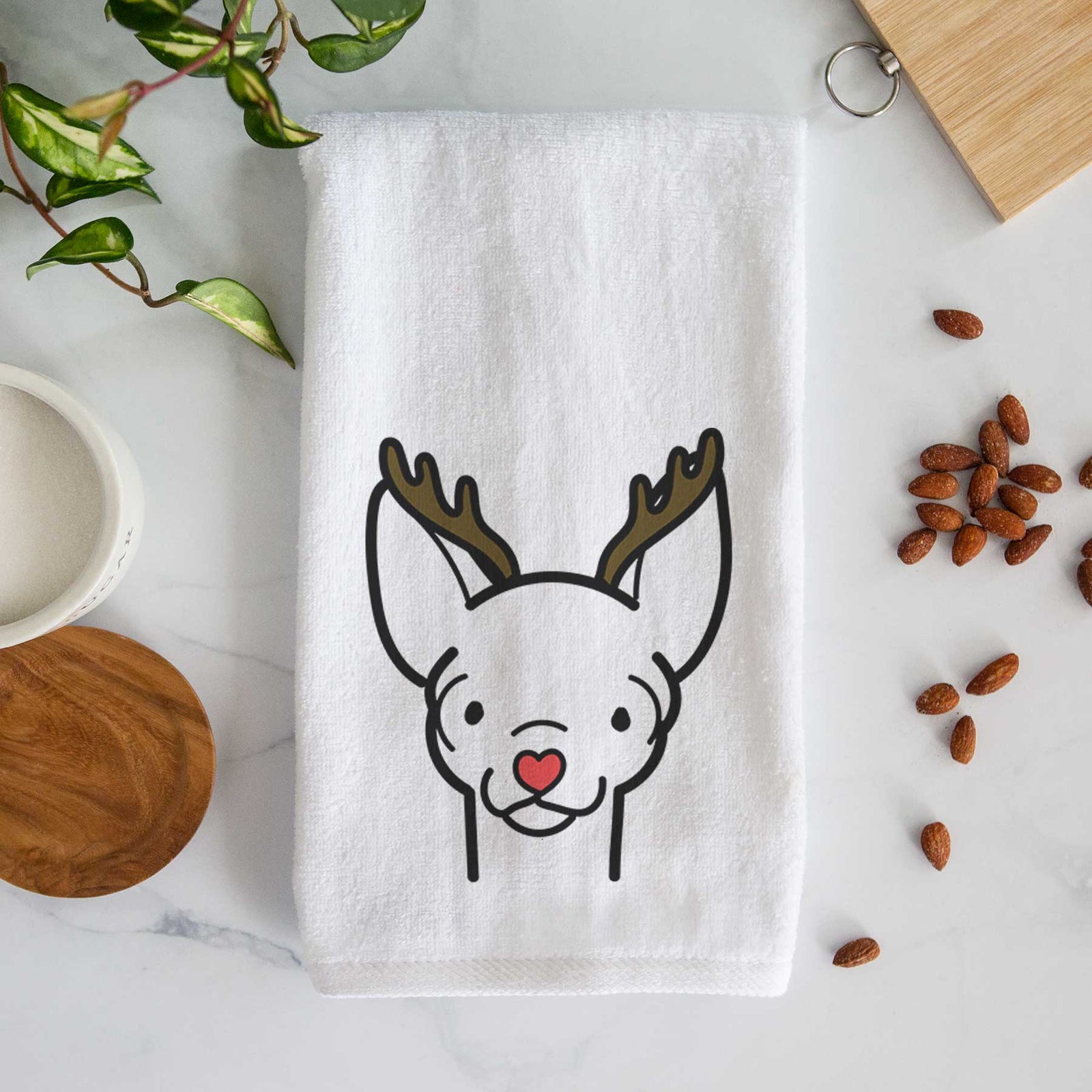 Minimalist line drawing of a Chihuahua with reindeer antlers and a red nose on a decorative hand towel