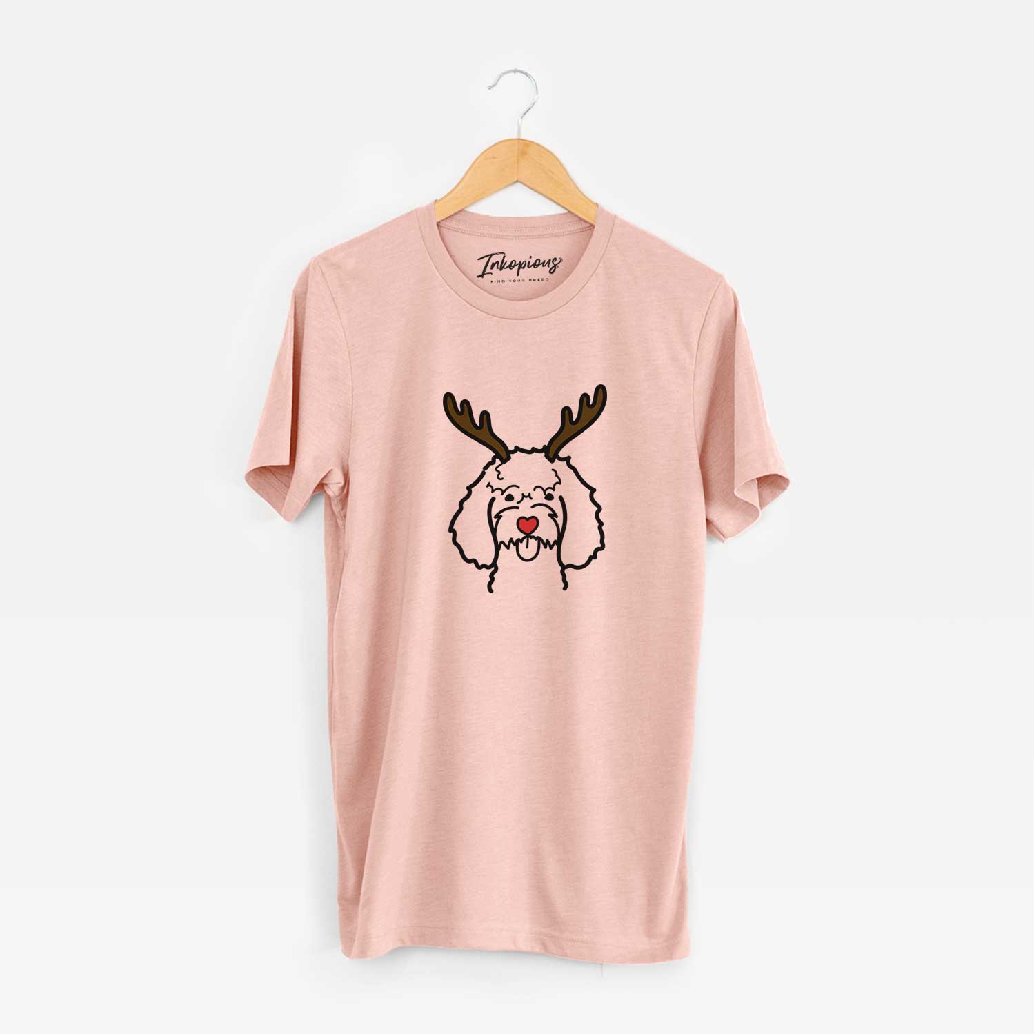 Minimalist line drawing of a Cockapoo with reindeer antlers and a red nose on a Peach Unisex crewneck