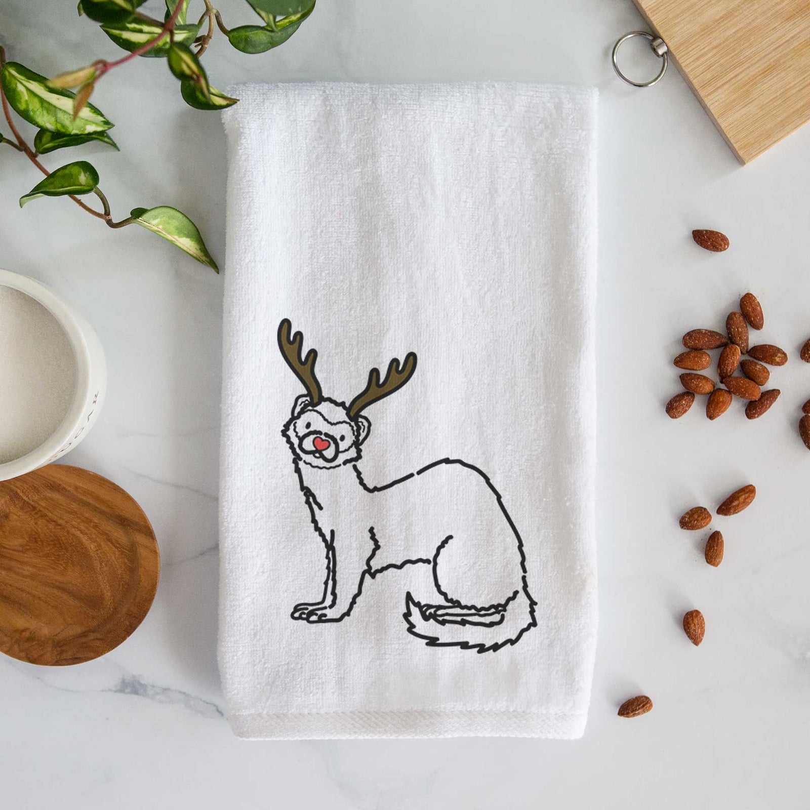 Minimalist line drawing of Fern the Ferret with reindeer antlers and a red nose on a decorative hand towel