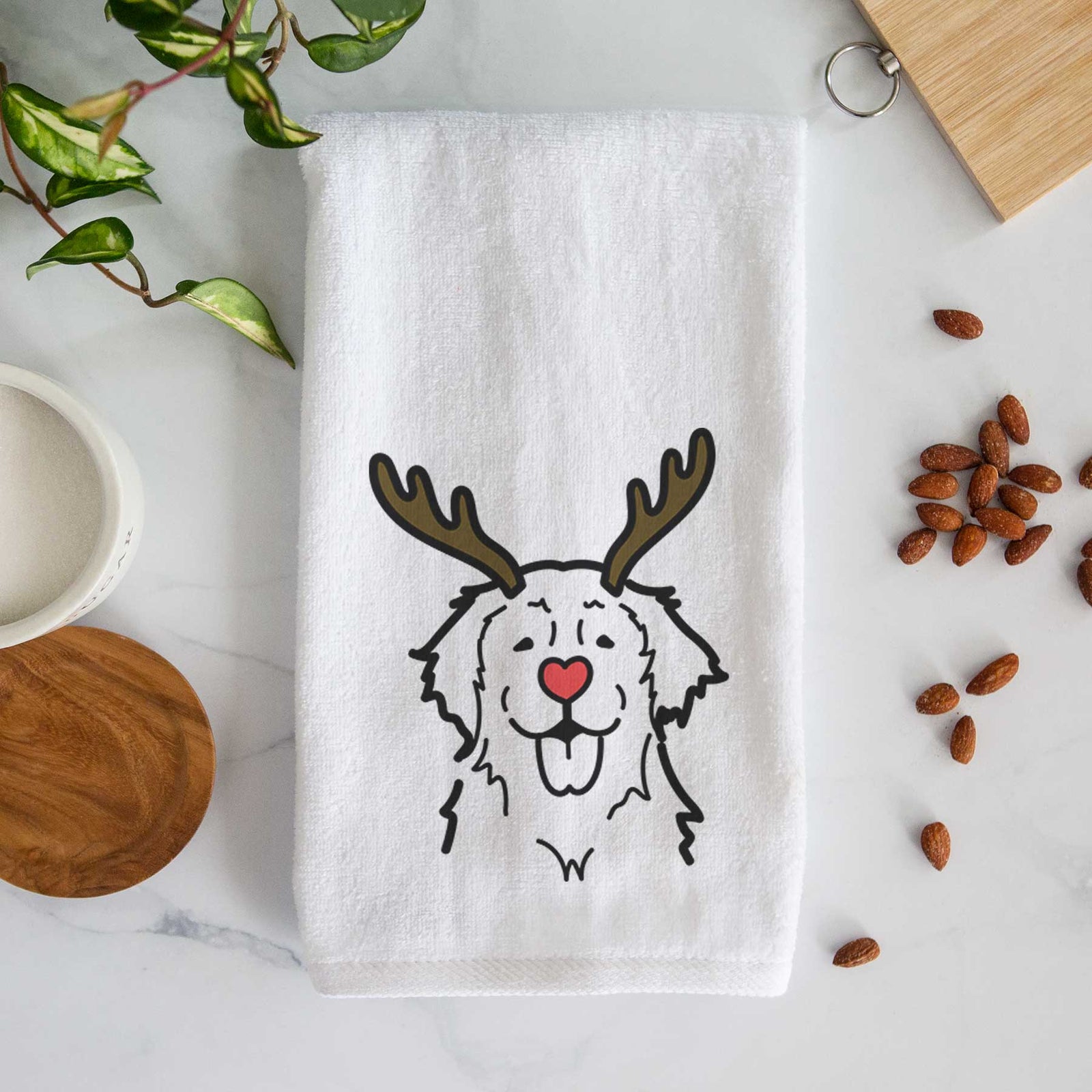 Minimalist line drawing of a Golden Retriever with reindeer antlers and a red nose on a decorative hand towel