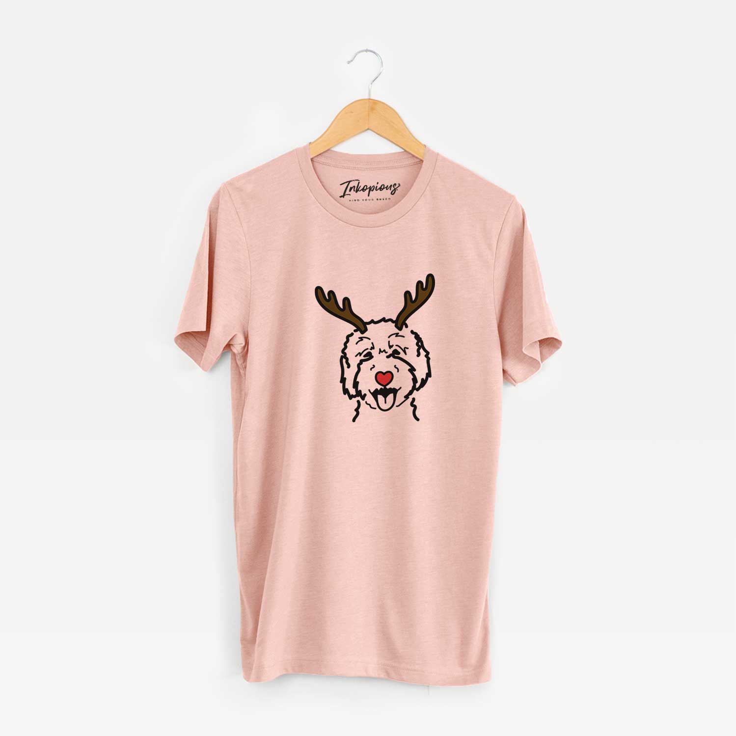 Minimalist line drawing of a Goldendoodle 2 with reindeer antlers and a red nose on a Peach Unisex crewneck
