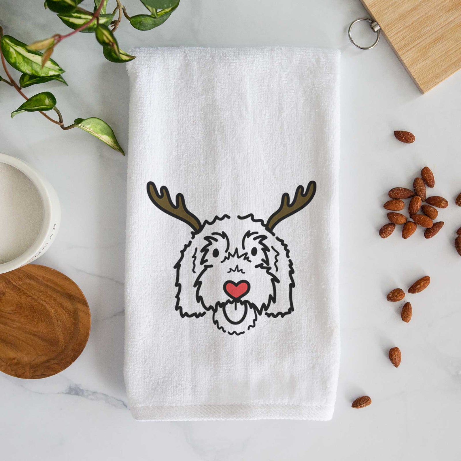 Minimalist line drawing of Gus the Goldendoodle with reindeer antlers and a red nose on a decorative hand towel