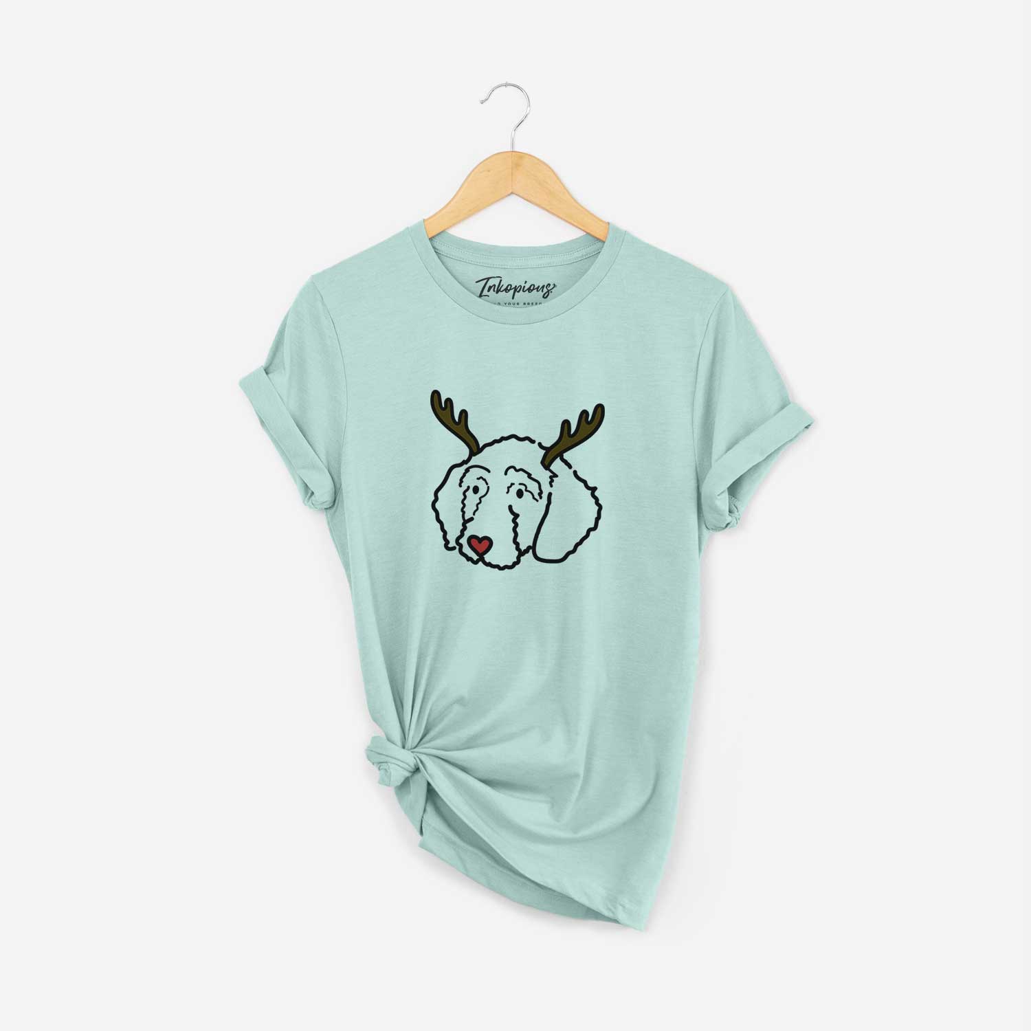 Minimalist line drawing of Hanna the Goldendoodle with reindeer antlers and a red nose on a Heather Sage Unisex crewneck