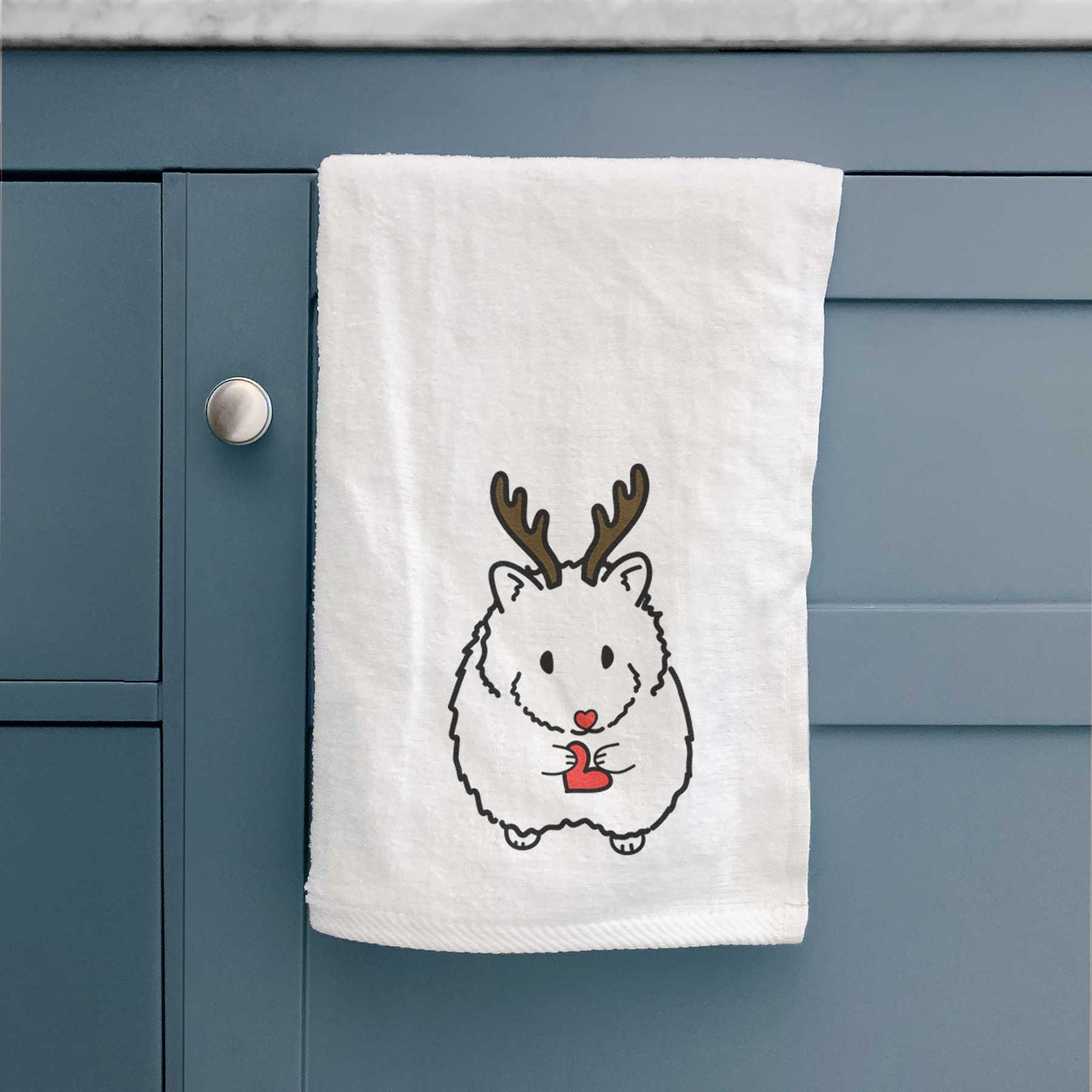 Minimalist line drawing of Hilga the Hamster with reindeer antlers and a red nose on a decorative hand towel