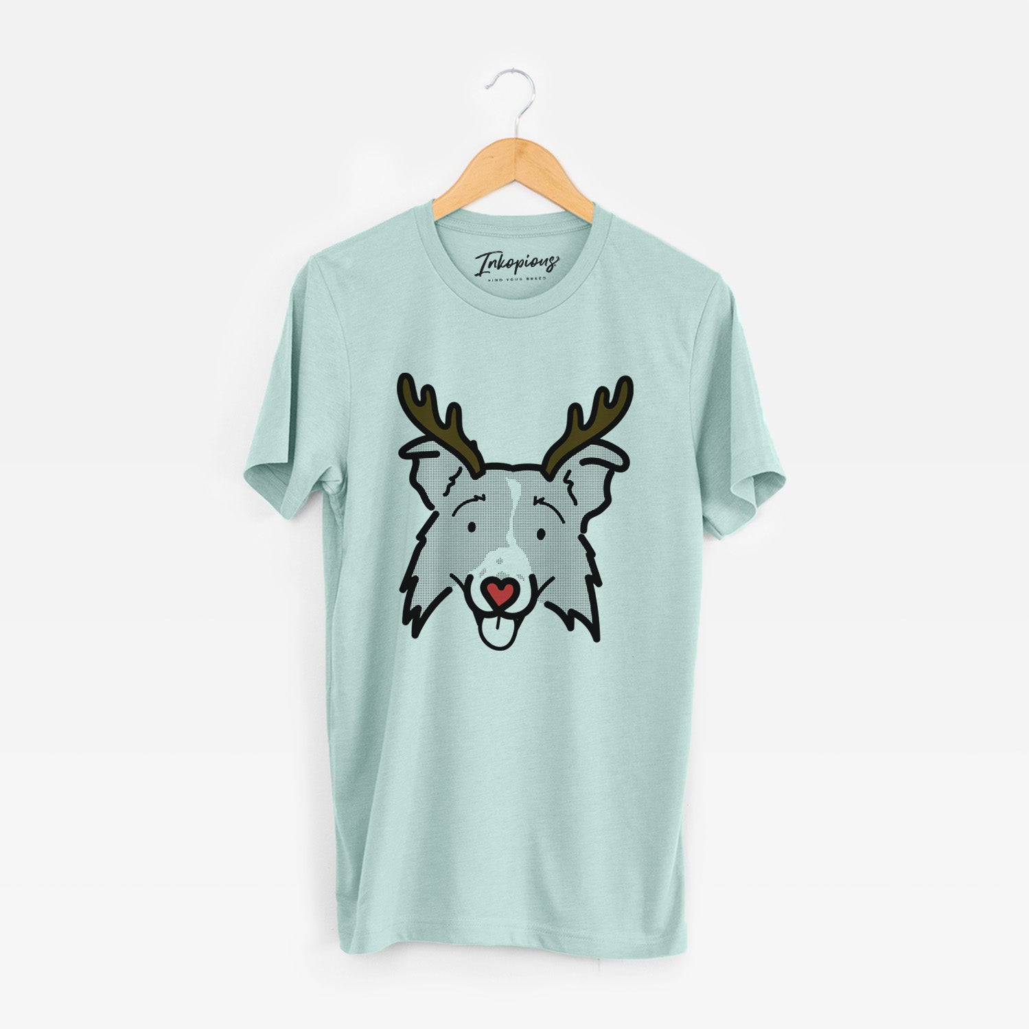 Minimalist line drawing of Jam the Border Collie 2.0 with reindeer antlers and a red nose on a Heather Sage Unisex crewneck