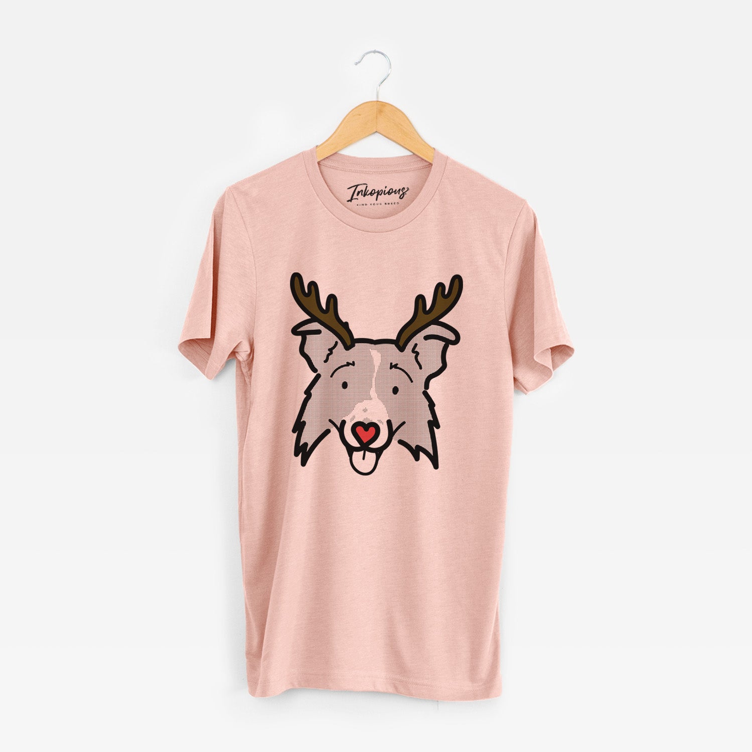 Minimalist line drawing of Jam the Border Collie 2.0 with reindeer antlers and a red nose on a Peach Unisex crewneck