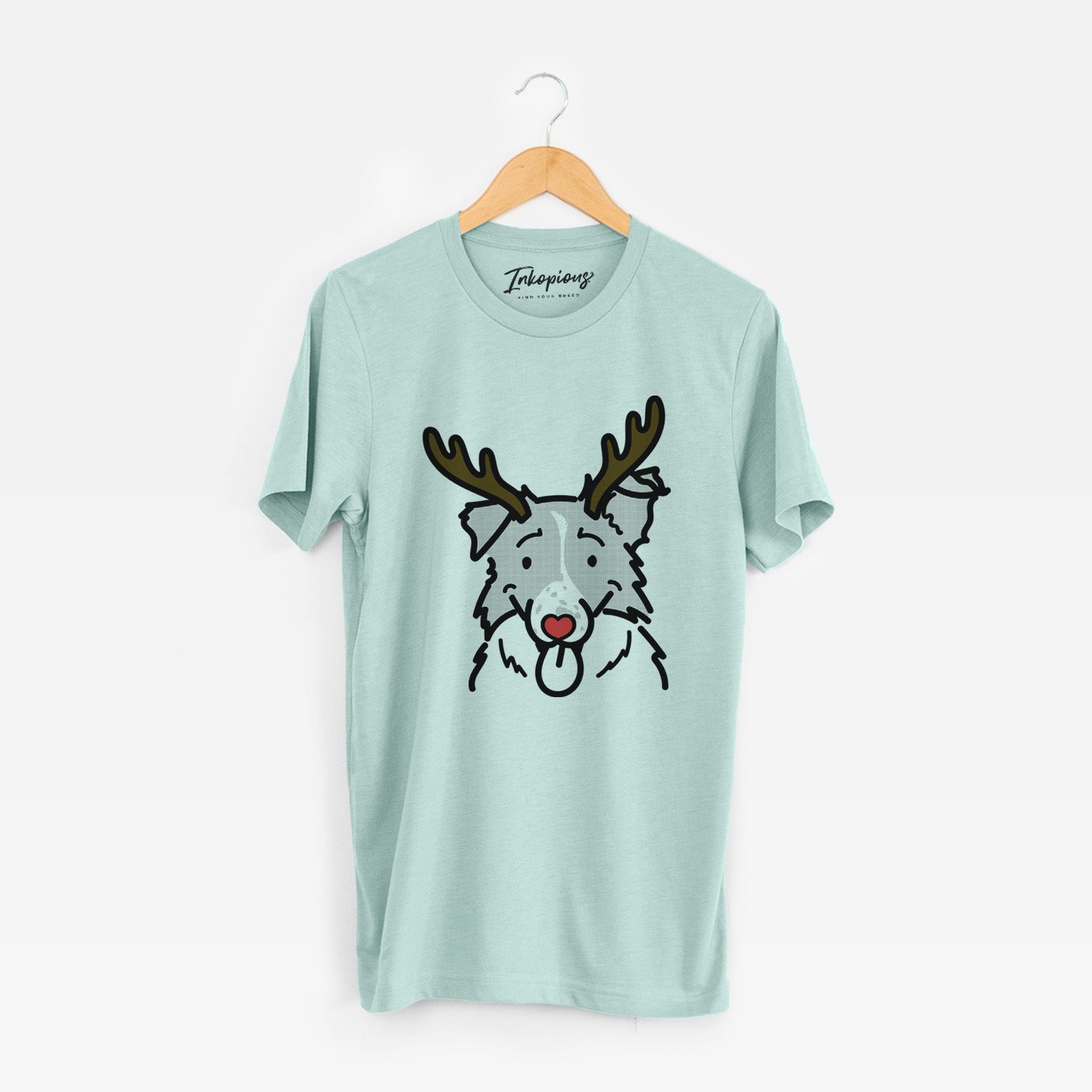 Minimalist line drawing of Jam the Border Collie with reindeer antlers and a red nose on a Heather Sage Unisex crewneck