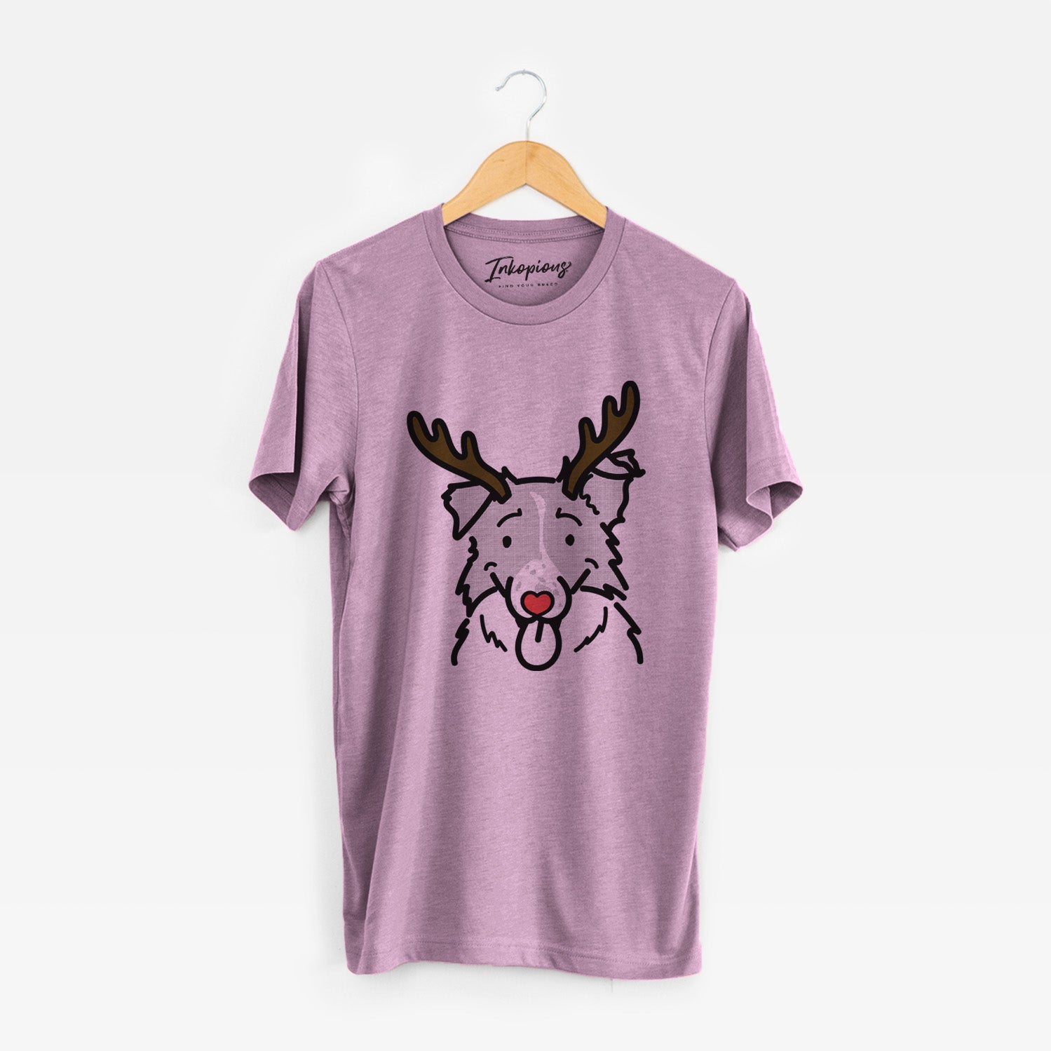 Minimalist line drawing of Jam the Border Collie with reindeer antlers and a red nose on an Orchid Unisex crewneck