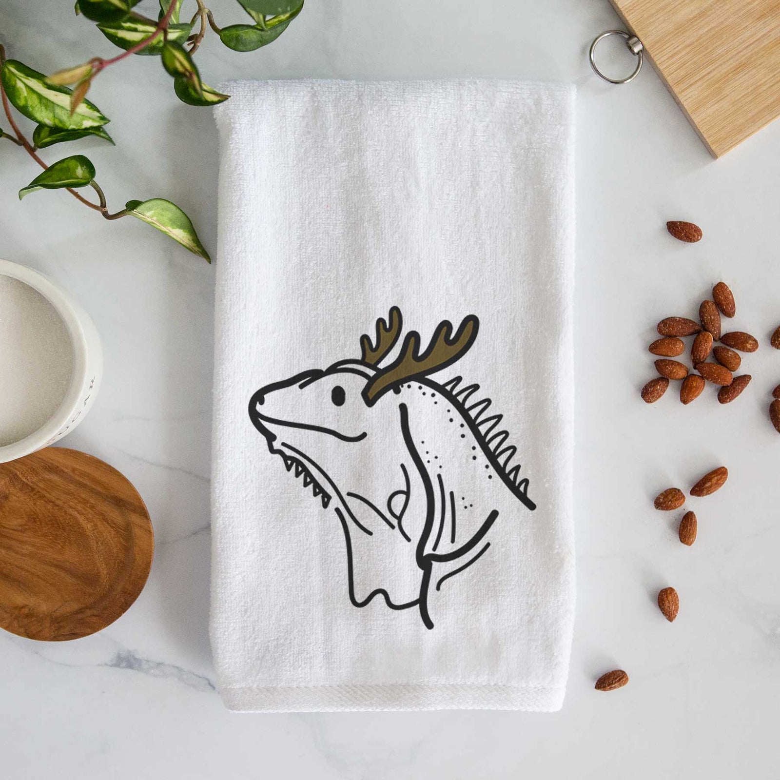Minimalist line drawing of Louie the Iguana with reindeer antlers and a red nose on a decorative hand towel