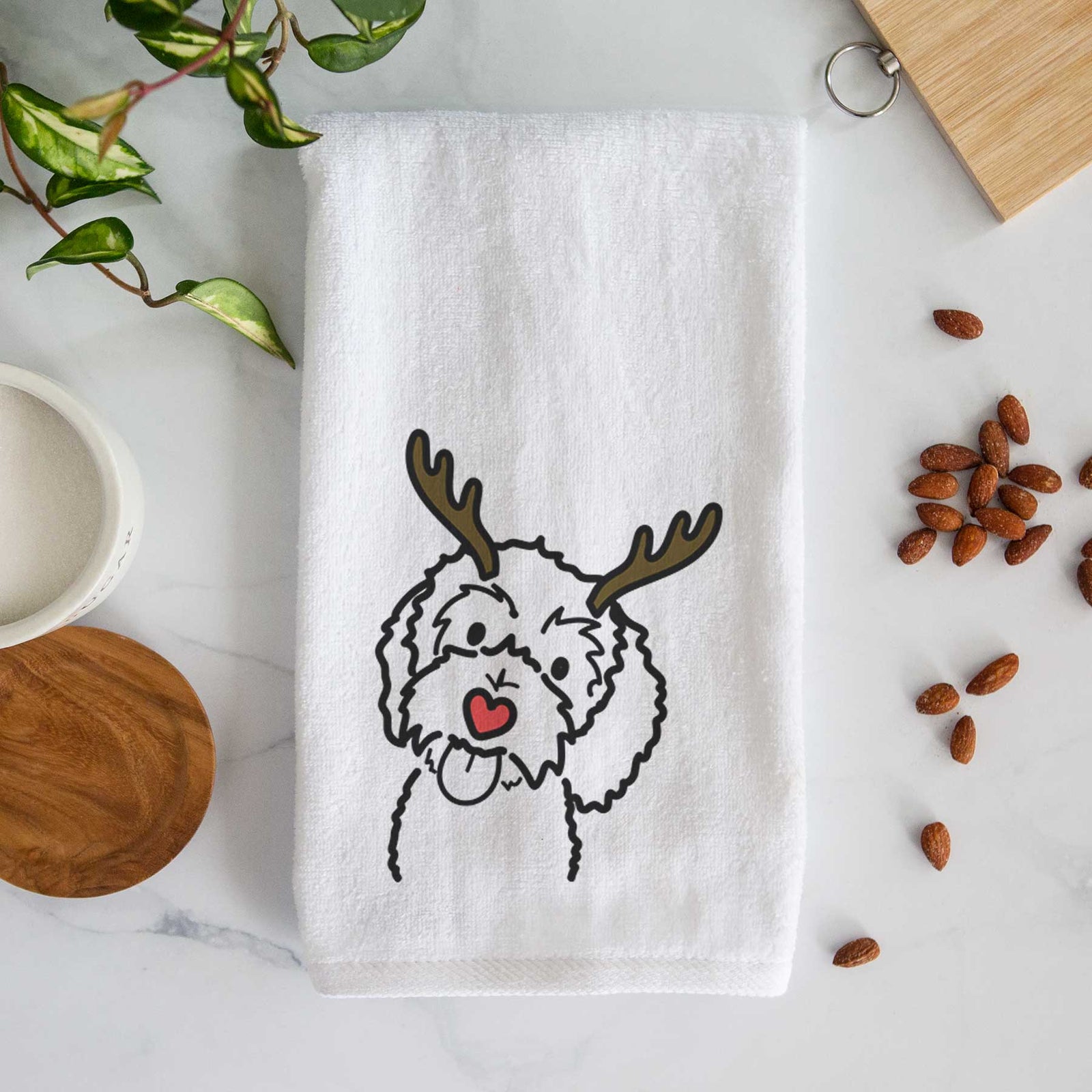Minimalist line drawing of Mabel the Bernedoodle with reindeer antlers and a red nose on a decorative hand towel