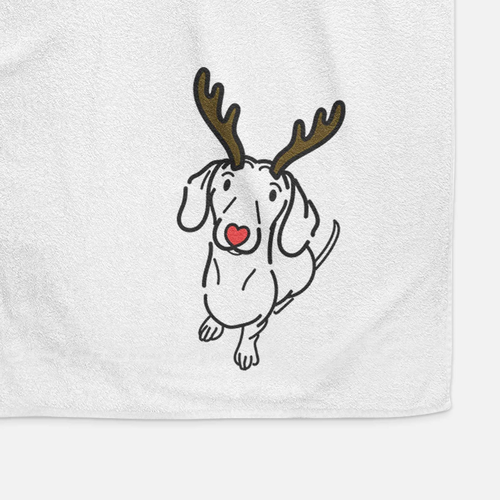 Minimalist line drawing of Moxie the Dachshund with reindeer antlers and a red nose on a decorative hand towel