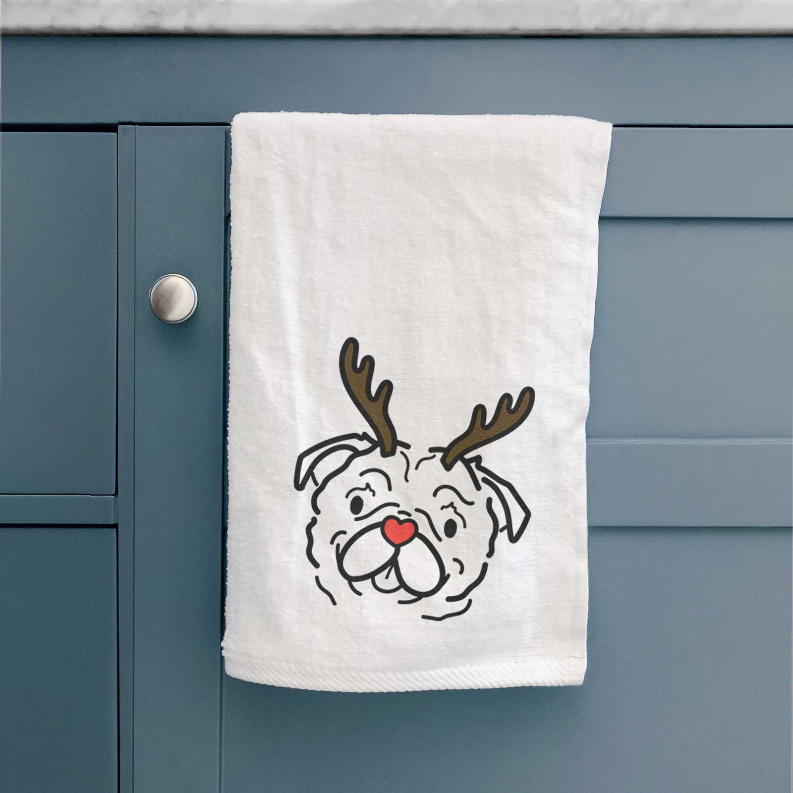 Minimalist line drawing of Pip the Pug with reindeer antlers and a red nose on a decorative hand towel