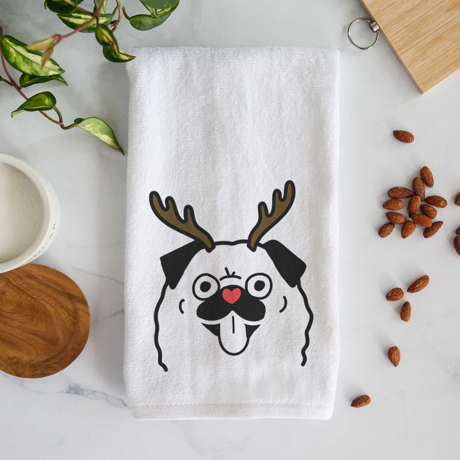 Minimalist line drawing of a Pug with reindeer antlers and a red nose on a decorative hand towel