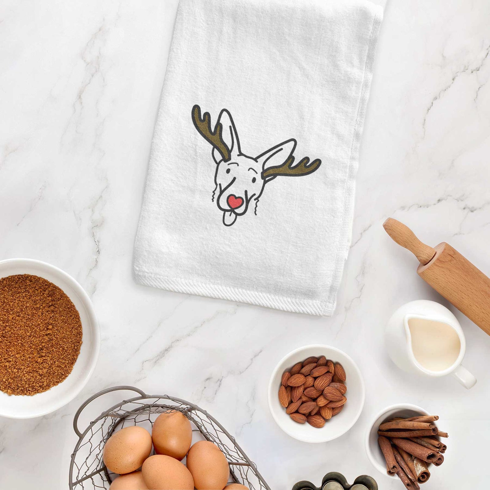 Minimalist line drawing of Rosie the Shepherd Mix with reindeer antlers and a red nose on a decorative hand towel
