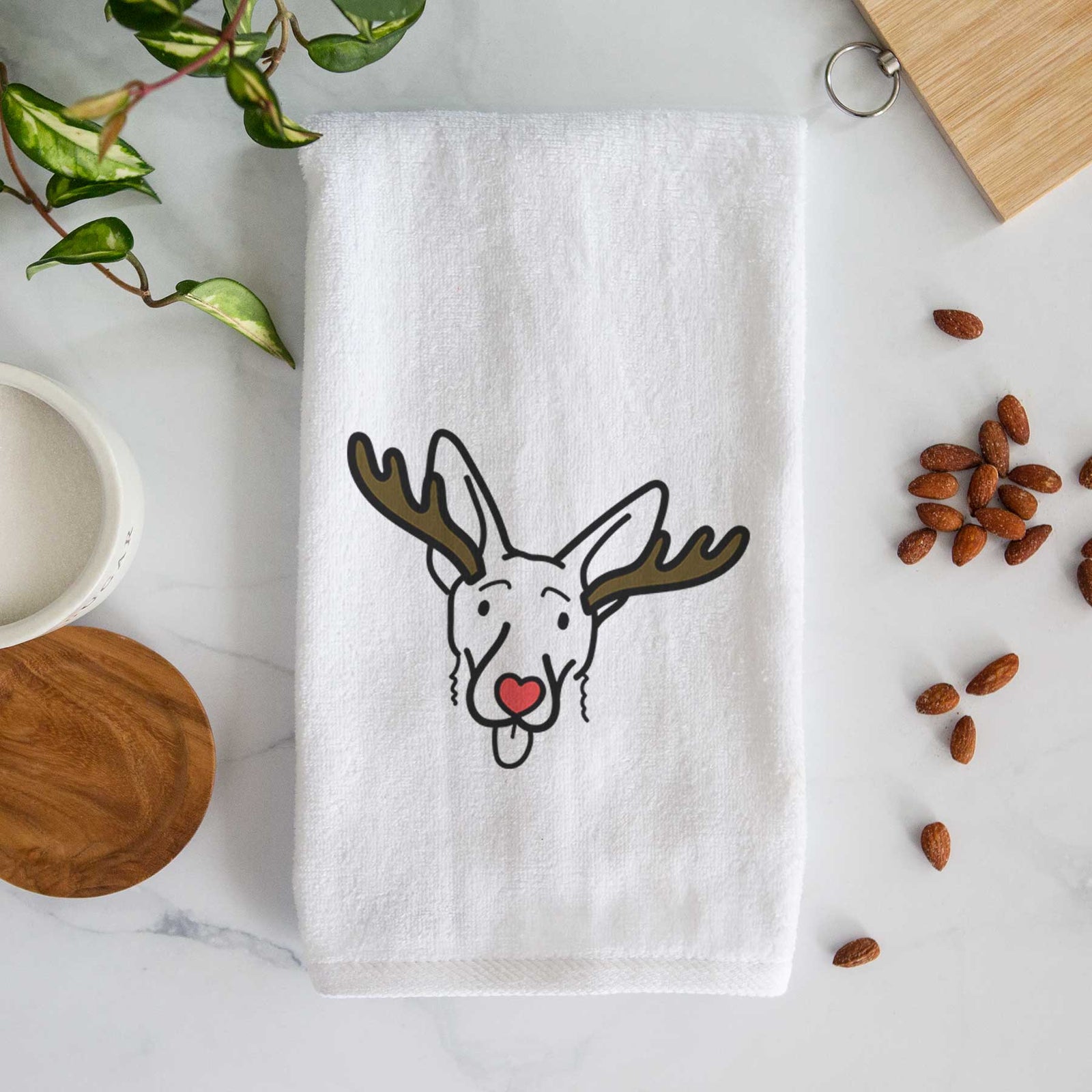 Minimalist line drawing of Rosie the Shepherd Mix with reindeer antlers and a red nose on a decorative hand towel