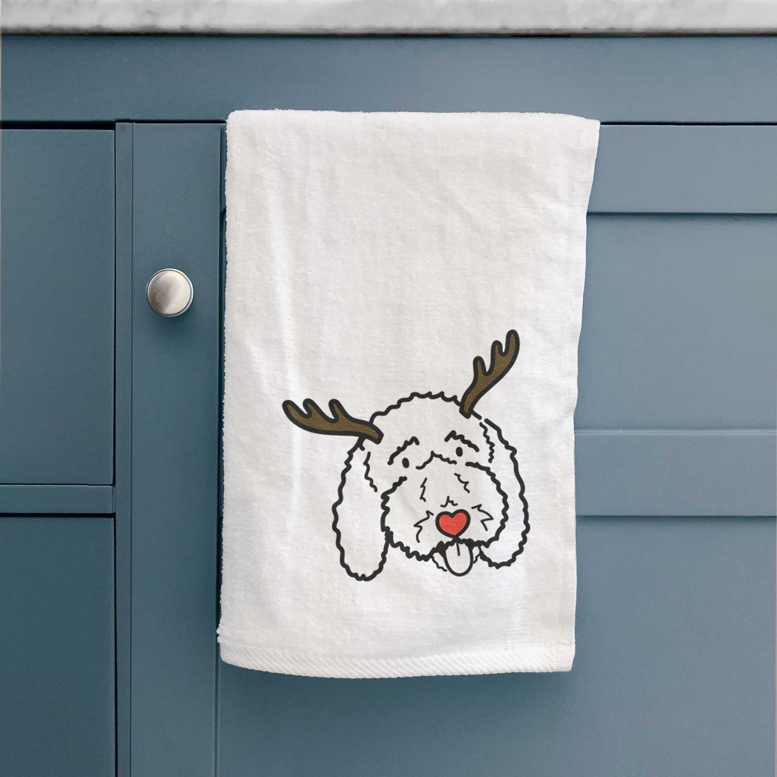 Minimalist line drawing of Ruby the Bernedoodle with reindeer antlers and a red nose on a decorative hand towel