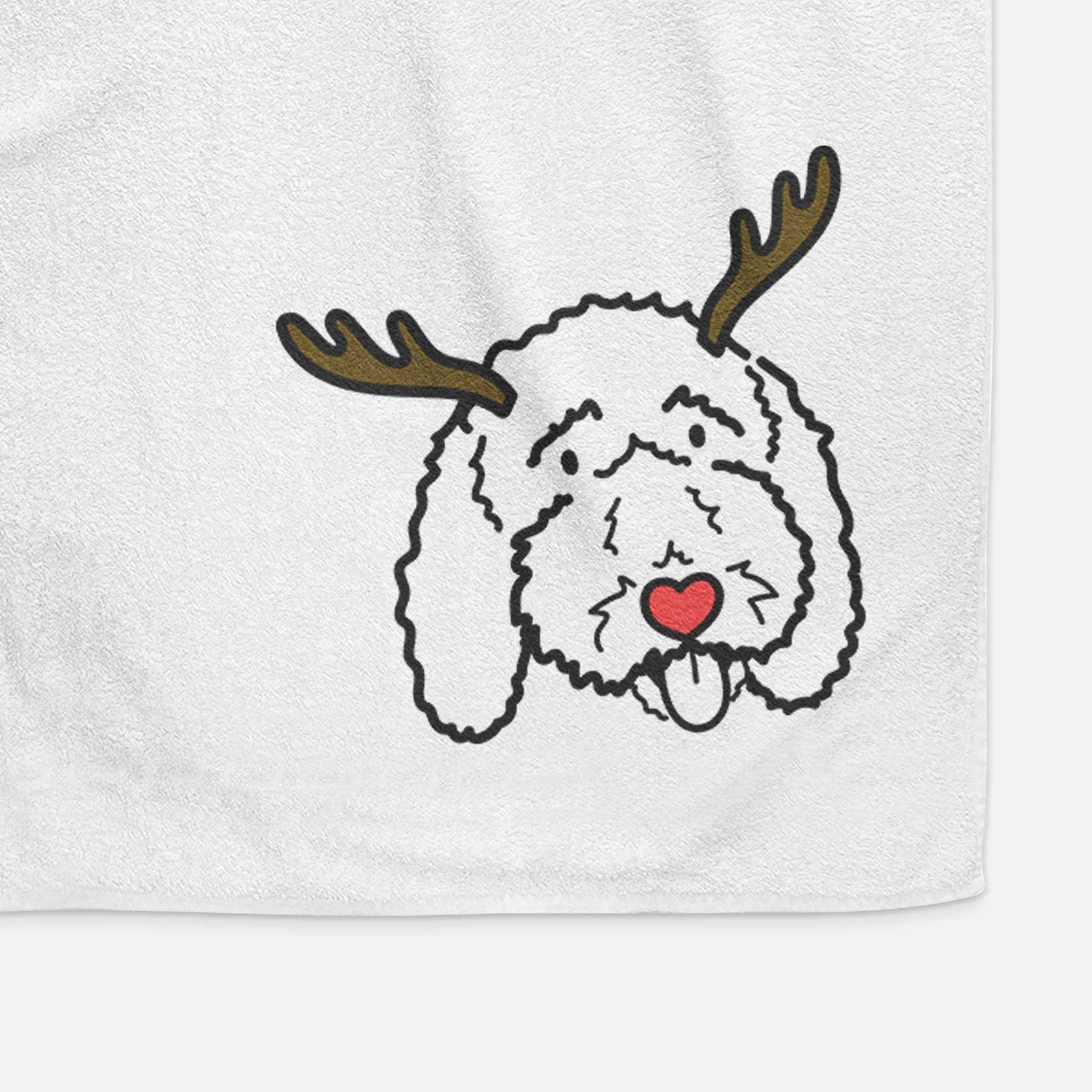 Minimalist line drawing of Ruby the Bernedoodle with reindeer antlers and a red nose on a decorative hand towel