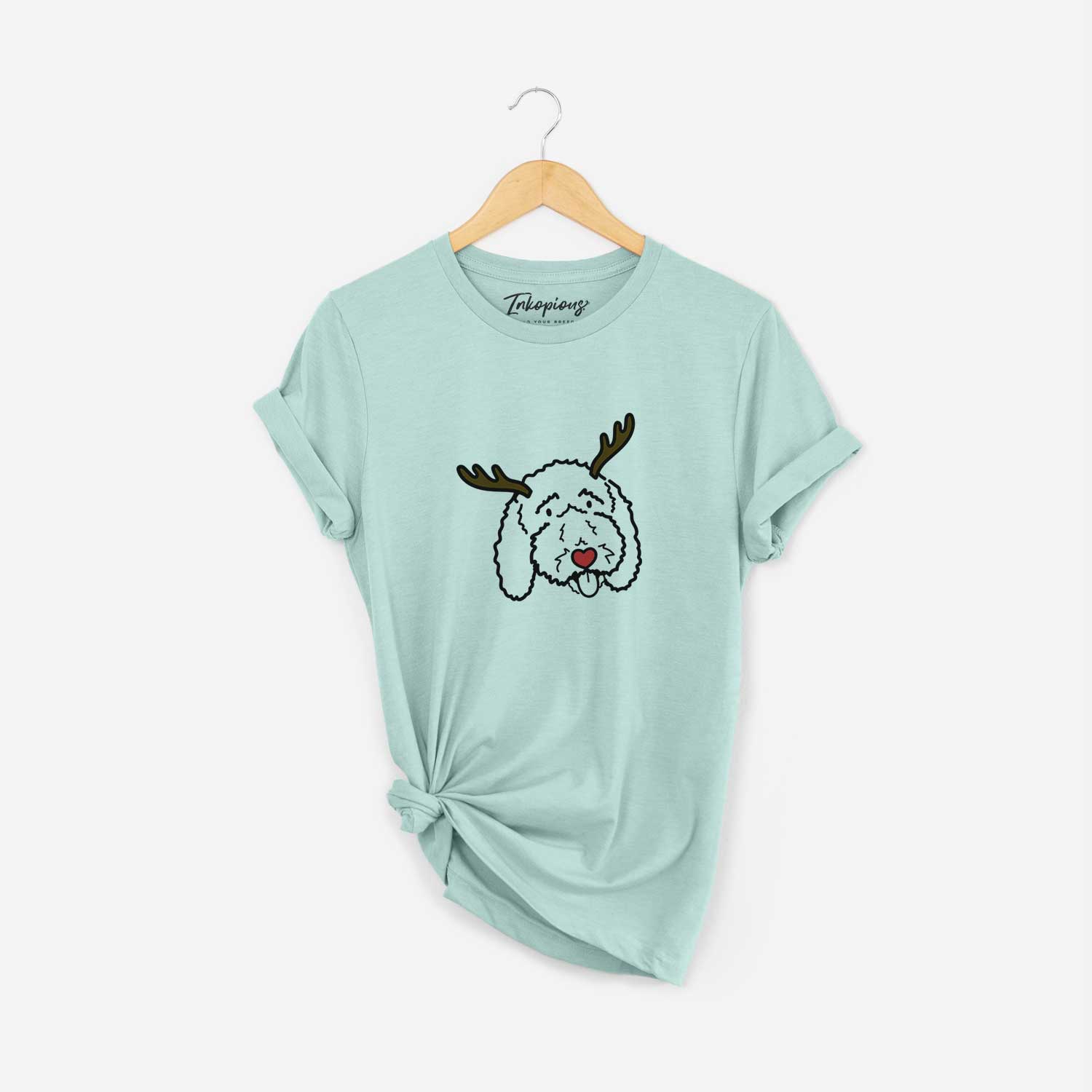 Minimalist line drawing of Ruby the Bernedoodle with reindeer antlers and a red nose on a Heather Sage Unisex crewneck