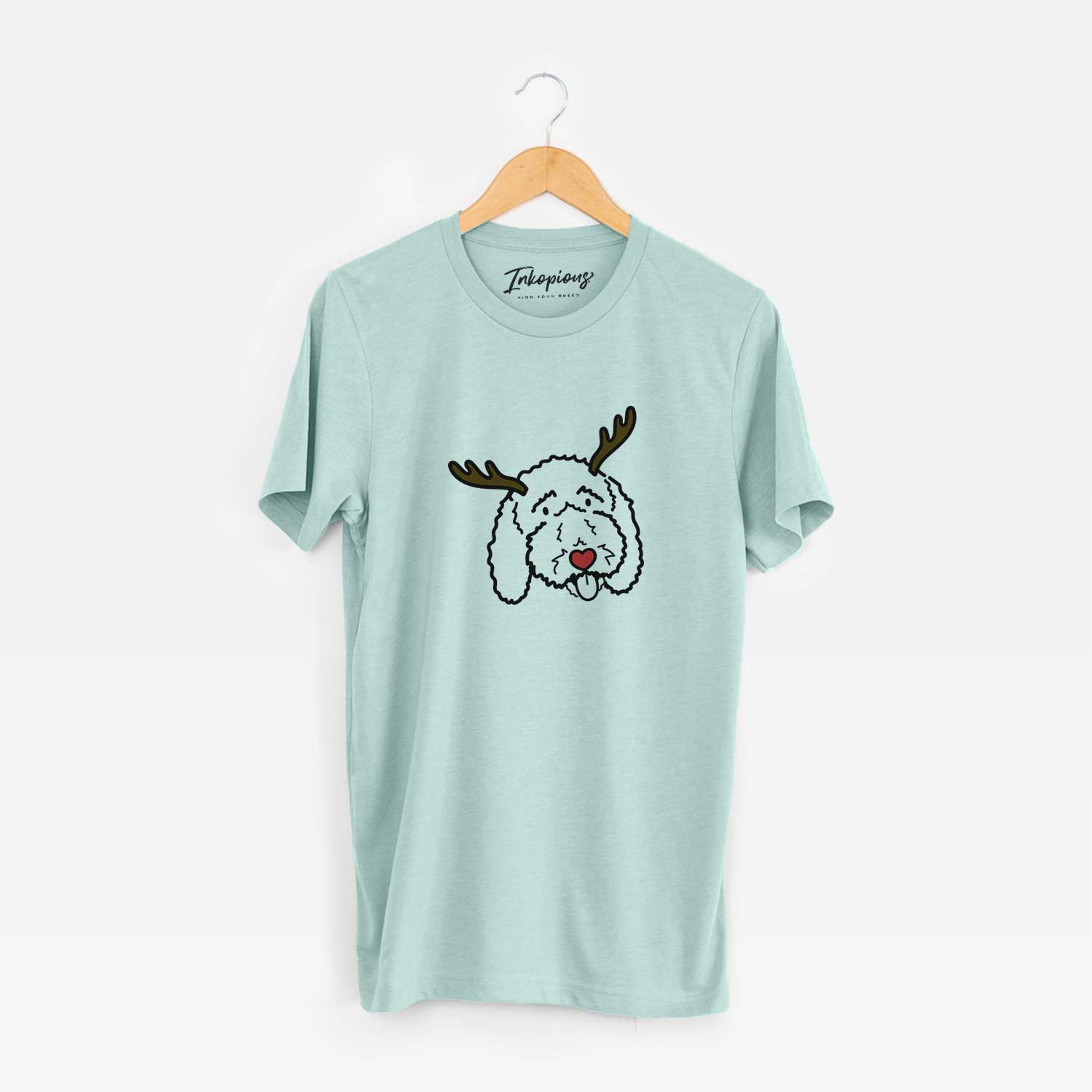 Minimalist line drawing of Ruby the Bernedoodle with reindeer antlers and a red nose on a Heather Sage Unisex crewneck