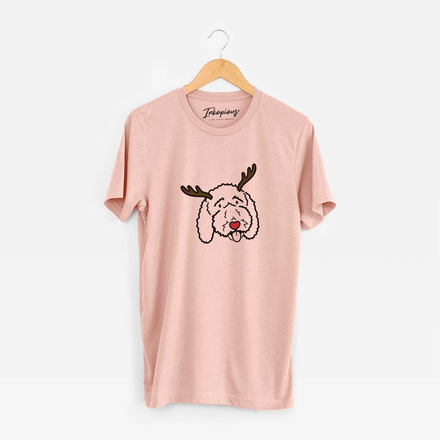 Minimalist line drawing of Ruby the Bernedoodle with reindeer antlers and a red nose on a Peach Unisex crewneck