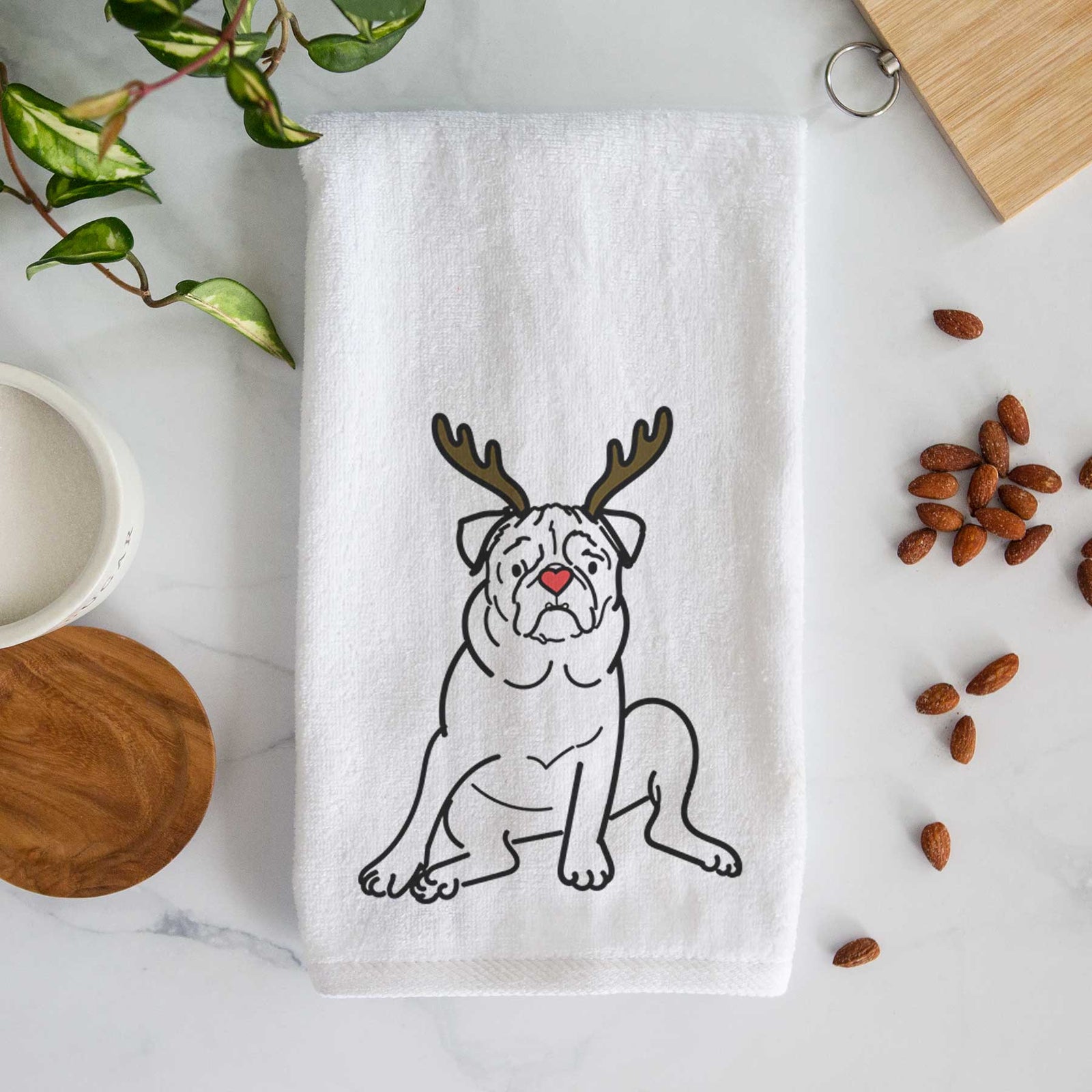 Minimalist line drawing of Rudy the Pug with reindeer antlers and a red nose on a decorative hand towel