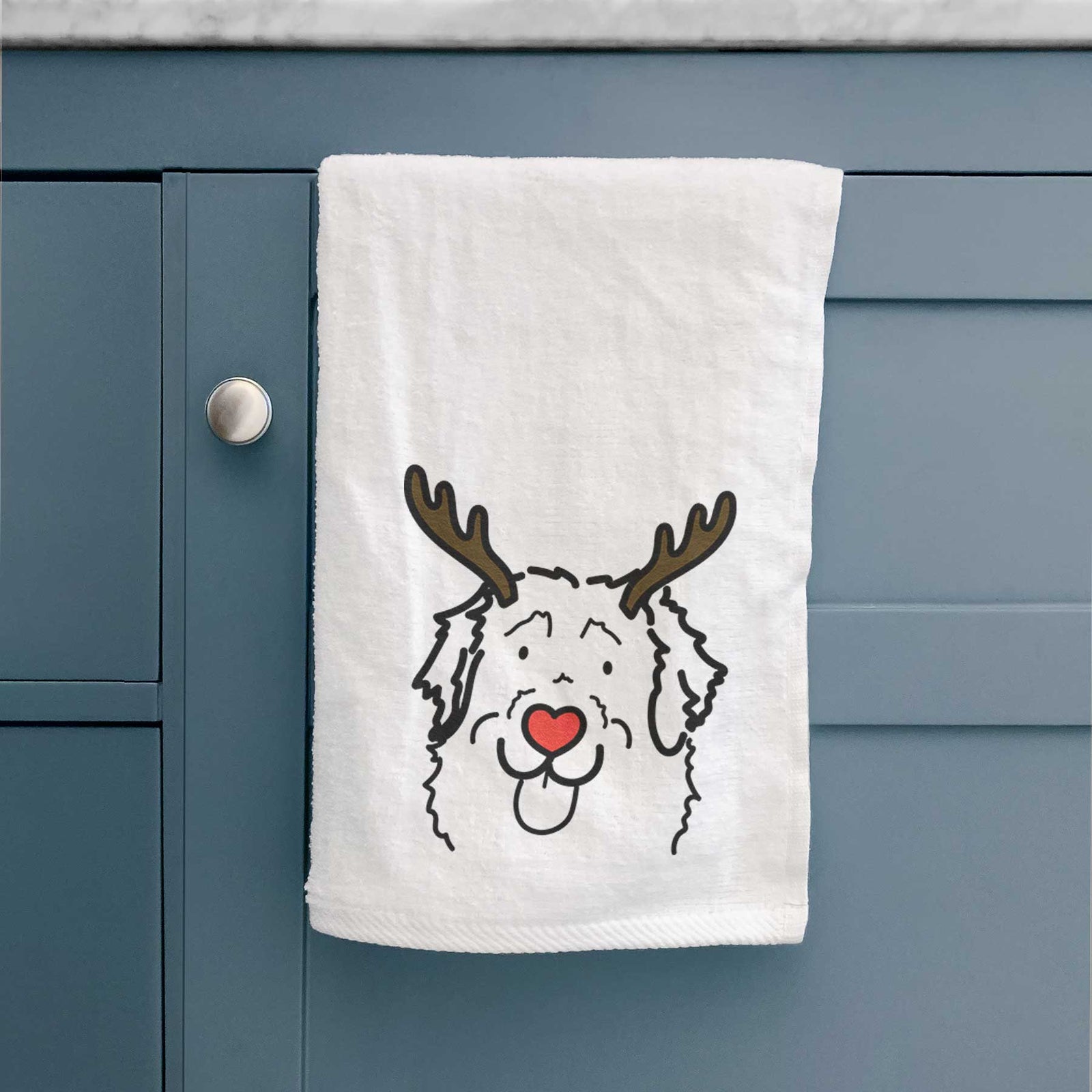 Minimalist line drawing of Sabre the Leonberger with reindeer antlers and a red nose on a decorative hand towel
