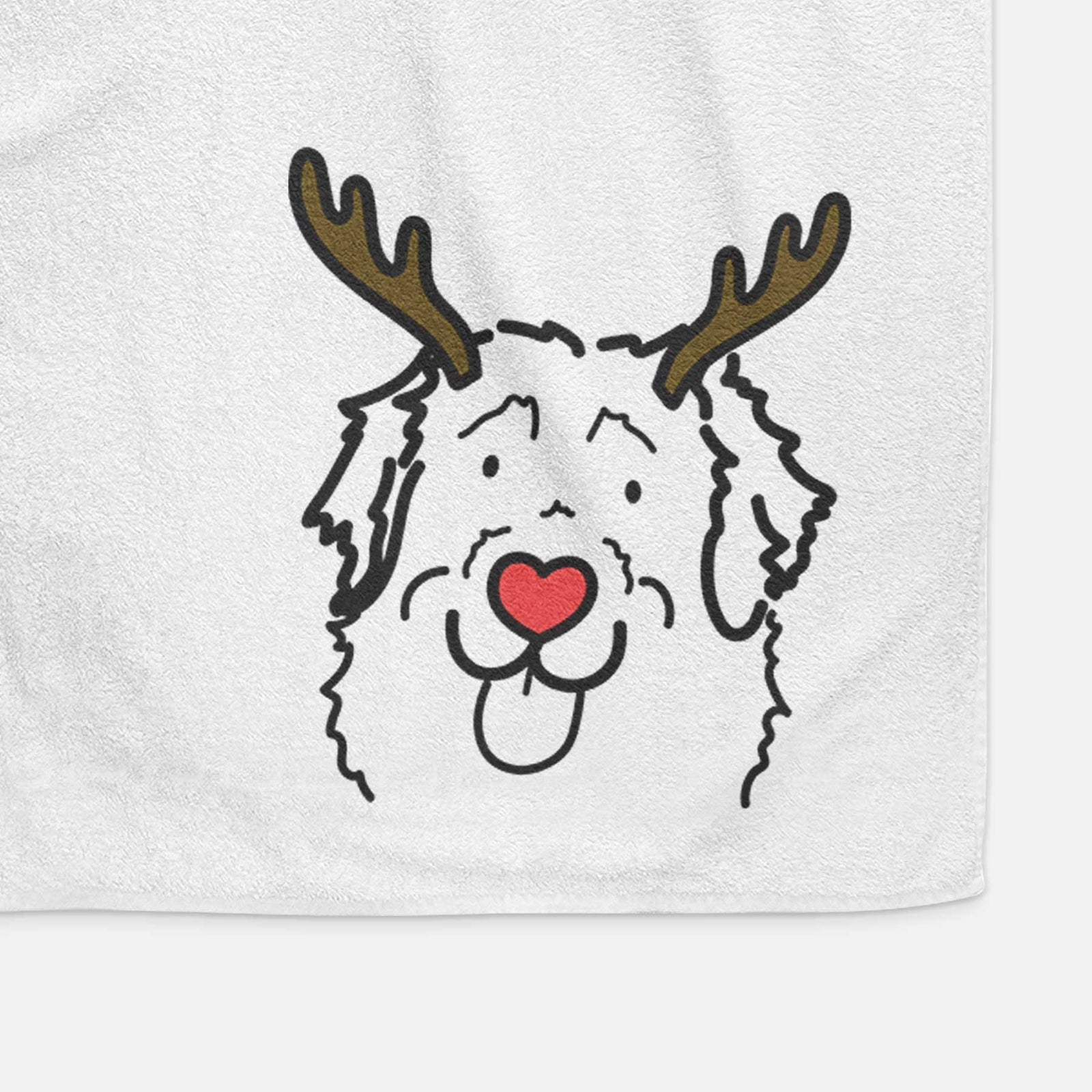 Minimalist line drawing of Sabre the Leonberger with reindeer antlers and a red nose on a decorative hand towel