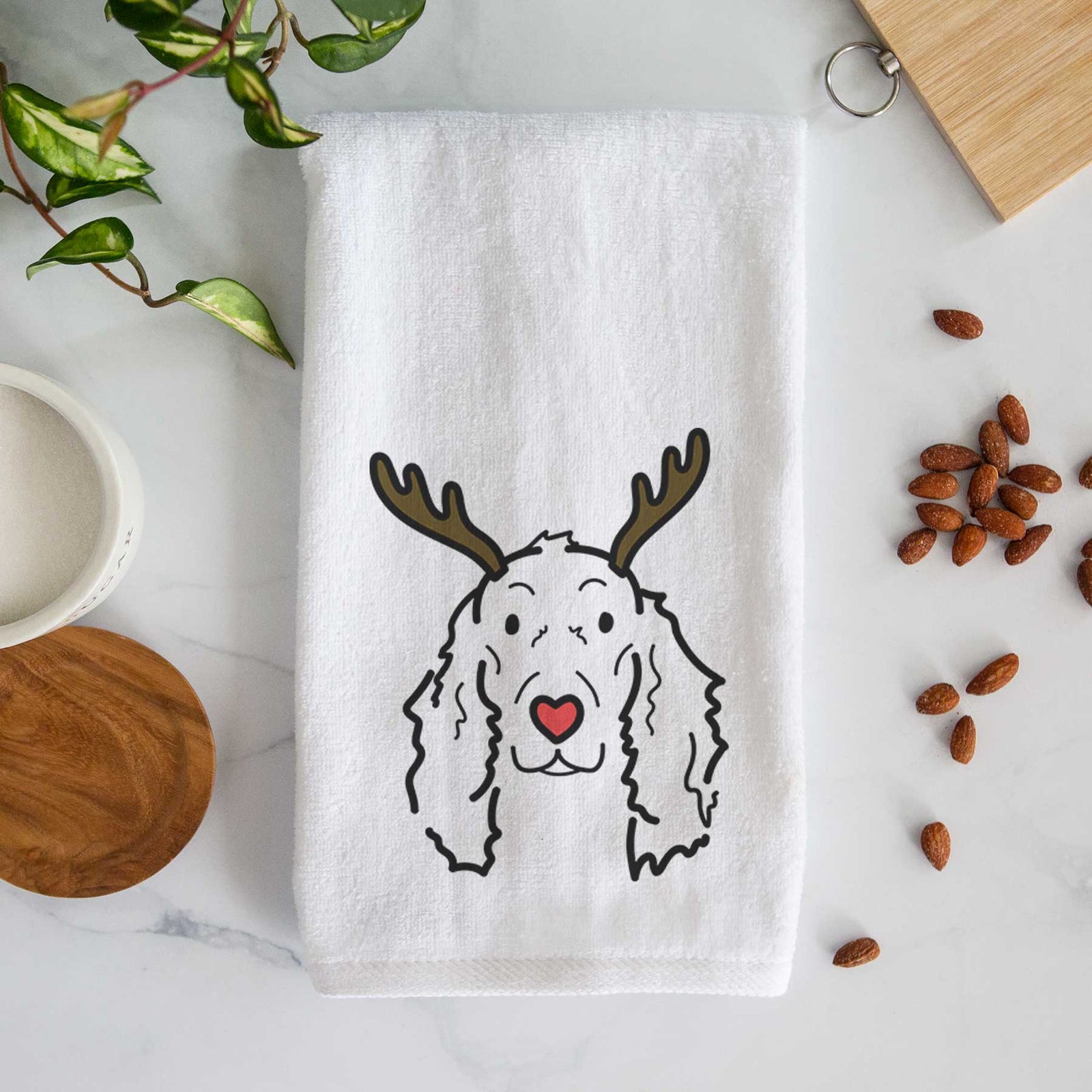 Minimalist line drawing of Seven the Irish Setter with reindeer antlers and a red nose on a decorative hand towel