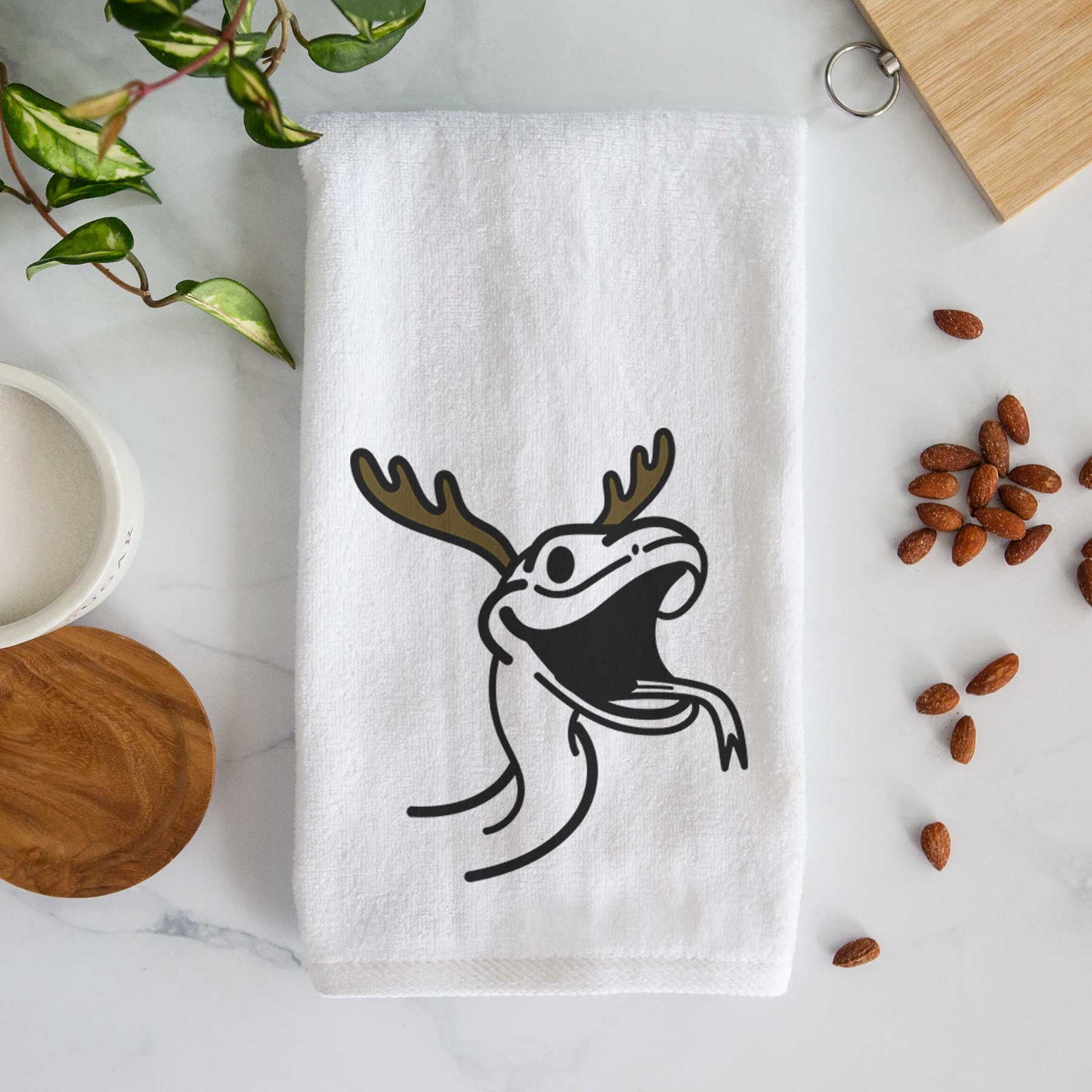 Minimalist line drawing of Spike the Snake with reindeer antlers and a red nose on a decorative hand towel