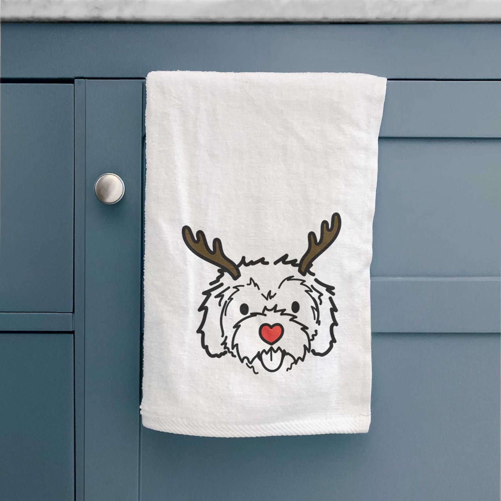 Minimalist line drawing of Sprinkles the Cockapoo with reindeer antlers and a red nose on a decorative hand towel