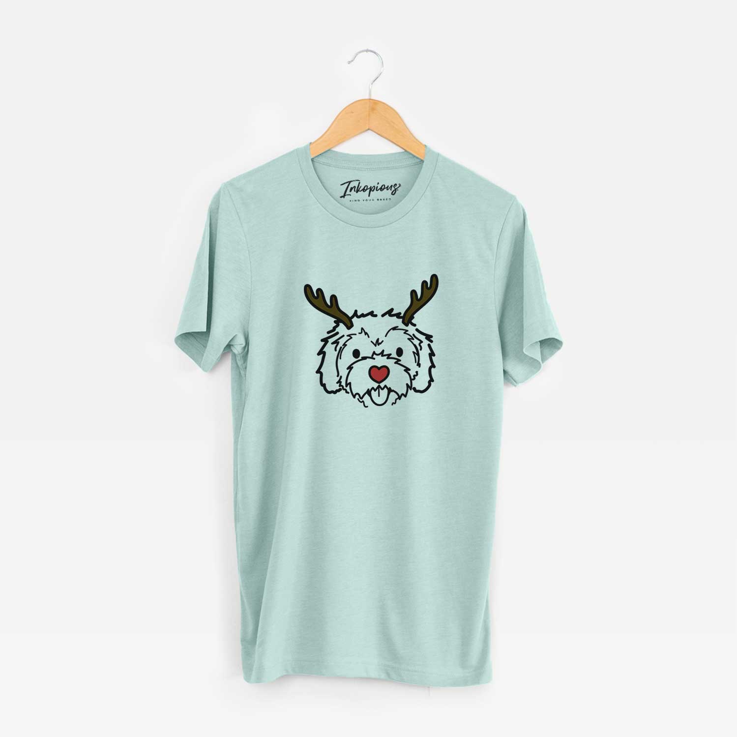 Minimalist line drawing of Sprinkles the Cockapoo with reindeer antlers and a red nose on a Heather Sage Unisex crewneck