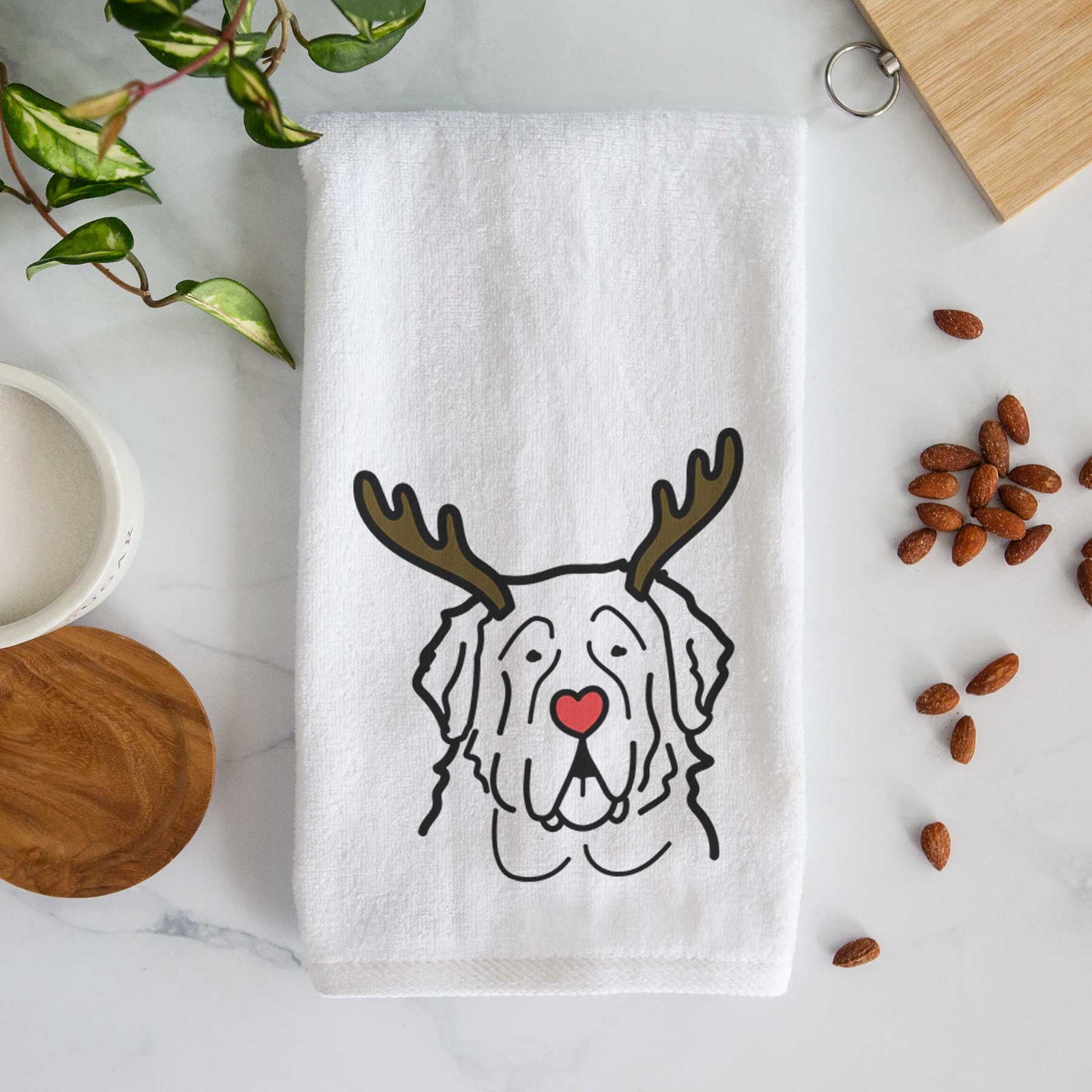 Minimalist line drawing of a Saint Bernard with reindeer antlers and a red nose on a decorative hand towel