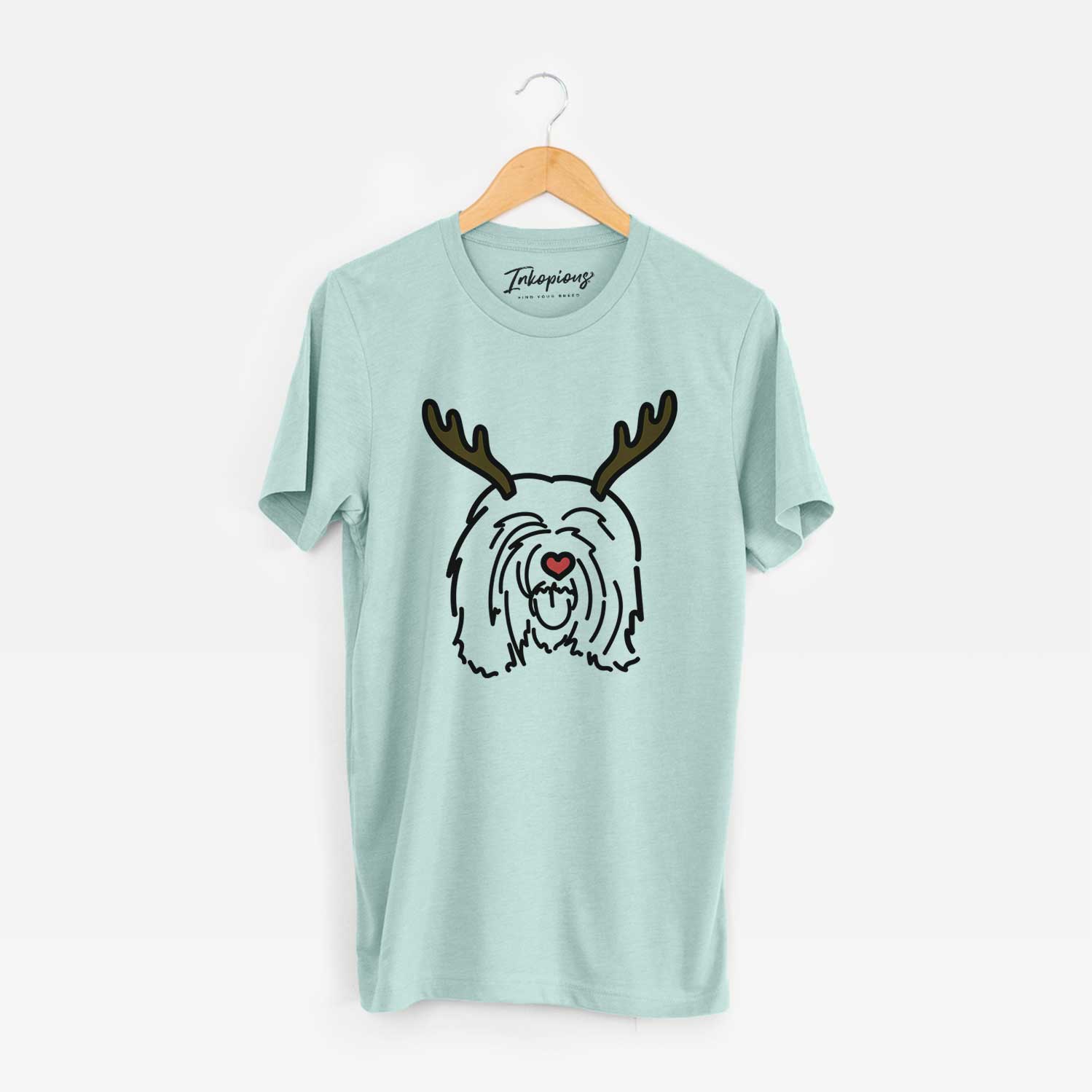 Minimalist line drawing of Stan the Tibetan Mastiff with reindeer antlers and a red nose on a Heather Sage Unisex crewneck
