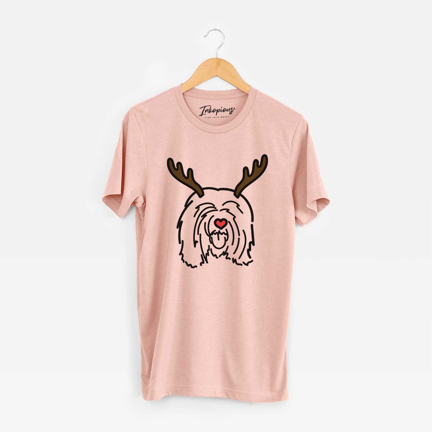 Minimalist line drawing of Stan the Tibetan Mastiff with reindeer antlers and a red nose on a Peach Unisex crewneck