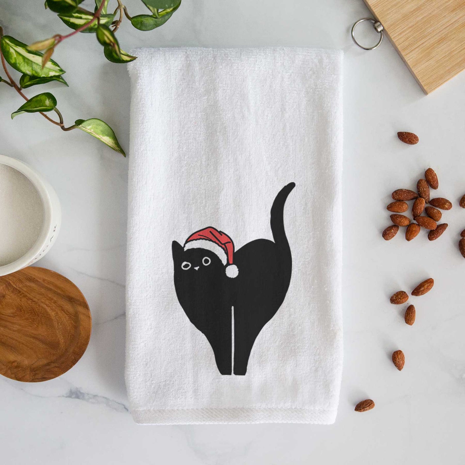 Minimalist line drawing of Bella the Black Cat wearing a Santa hat on a decorative hand towel