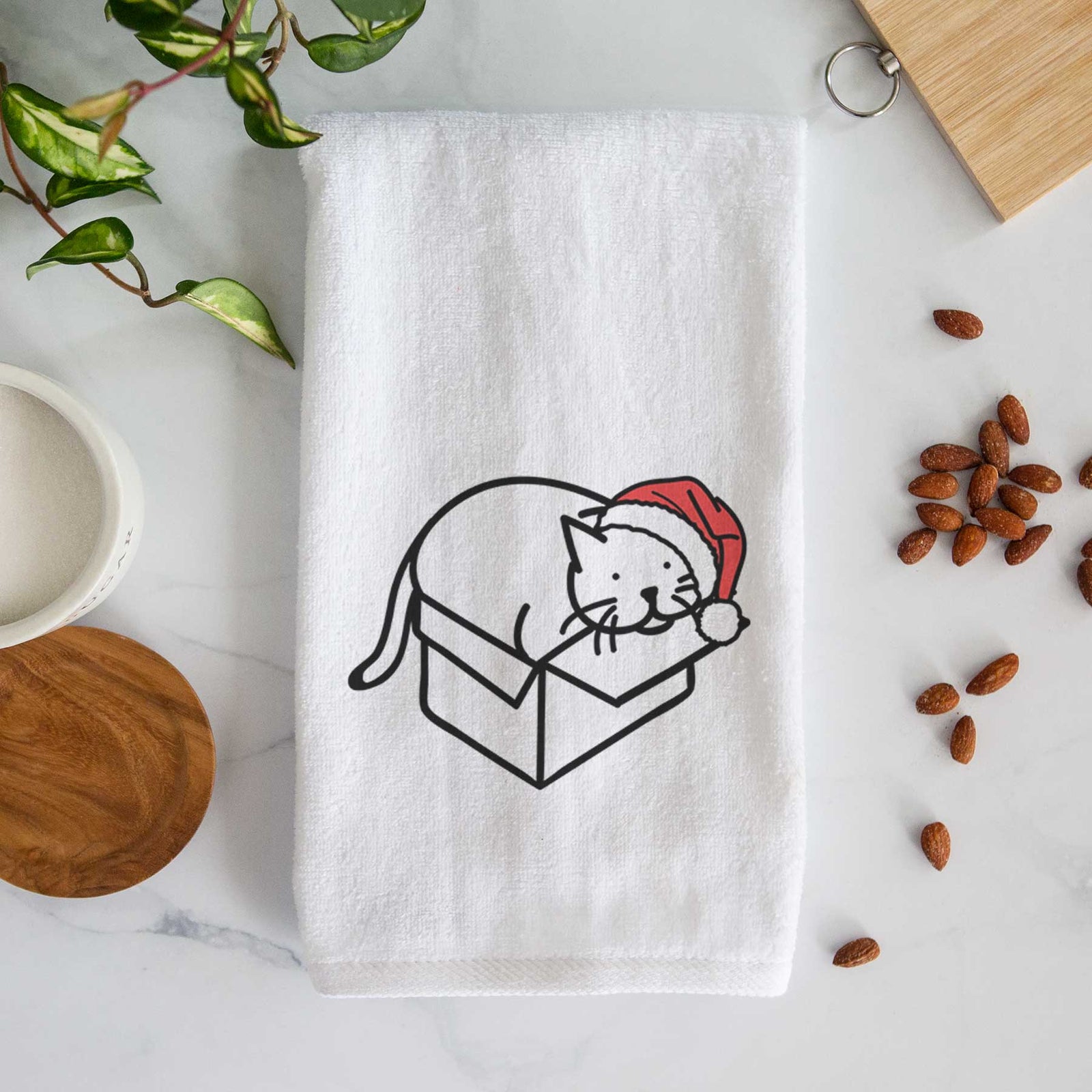 Minimalist line drawing of Charlie the Cat in a Box wearing a Santa hat on a decorative hand towel