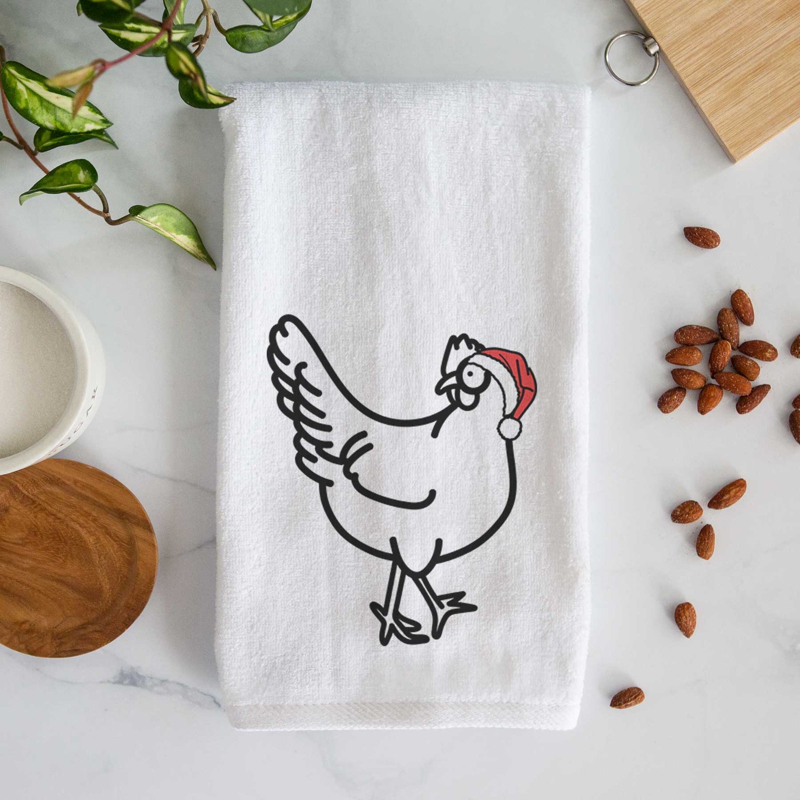Minimalist line drawing of Daisy the Chicken wearing a Santa hat on a decorative hand towel