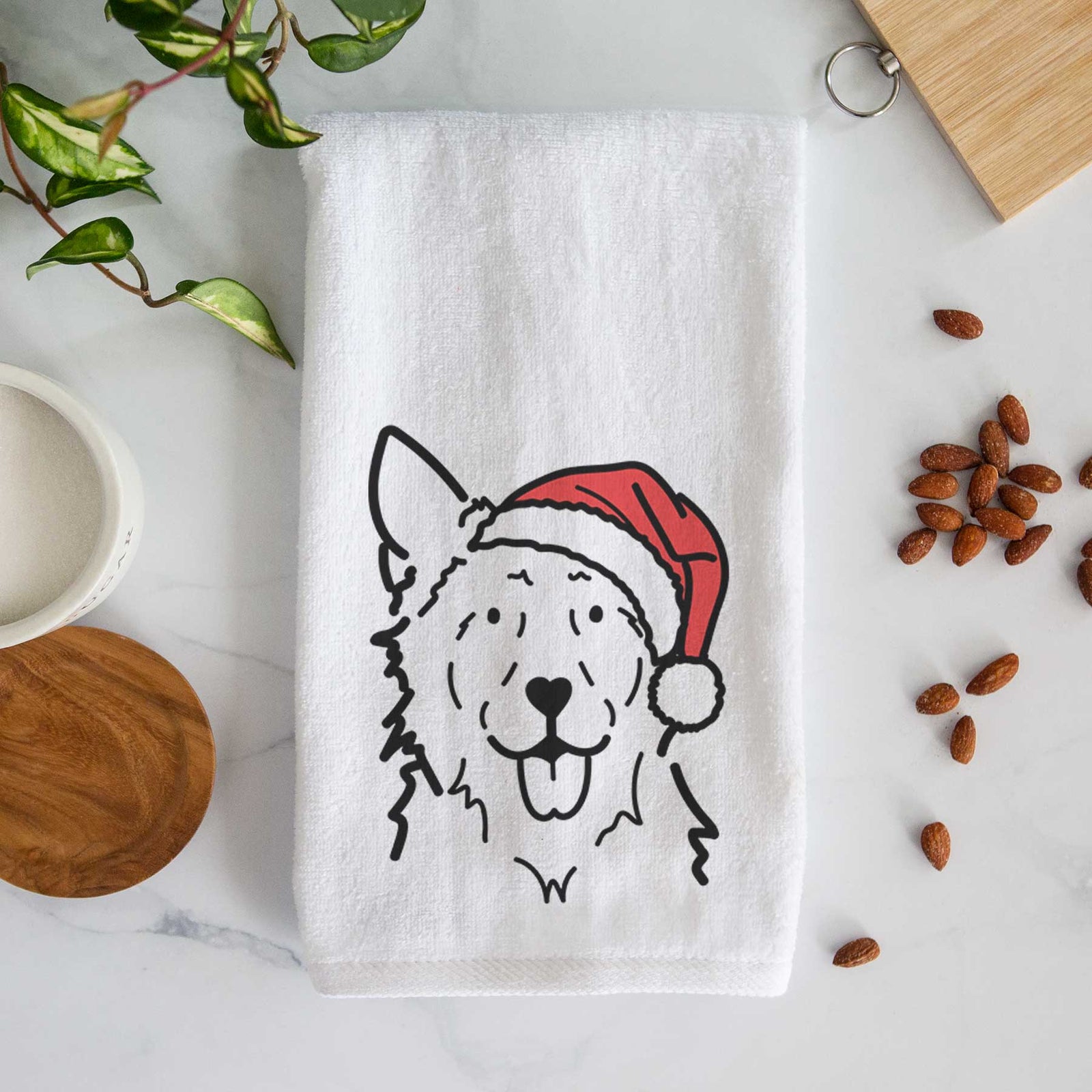 Minimalist line drawing of Jack the Mudi wearing a Santa hat on a decorative hand towel