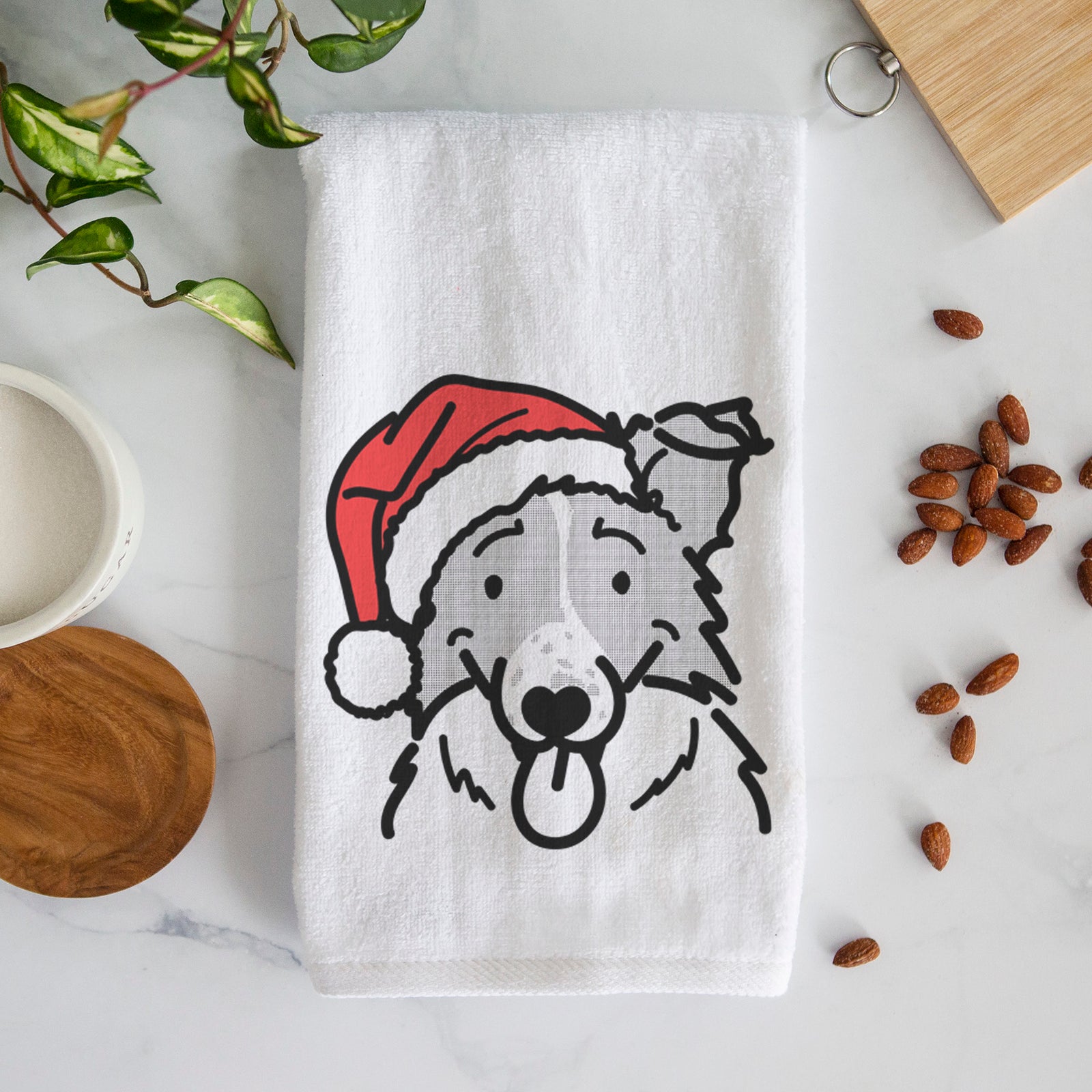 Minimalist line drawing of Jam the Border Collie wearing a Santa hat on a decorative hand towel