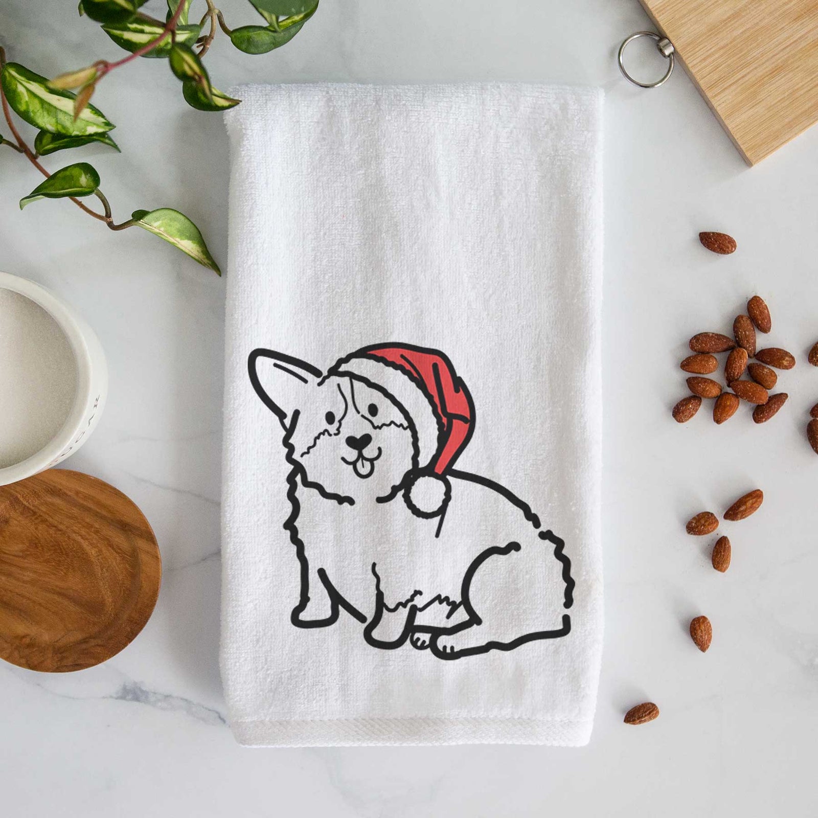 Minimalist line drawing of Millie the Pembroke Welsh Corgi wearing a Santa hat on a decorative hand towel
