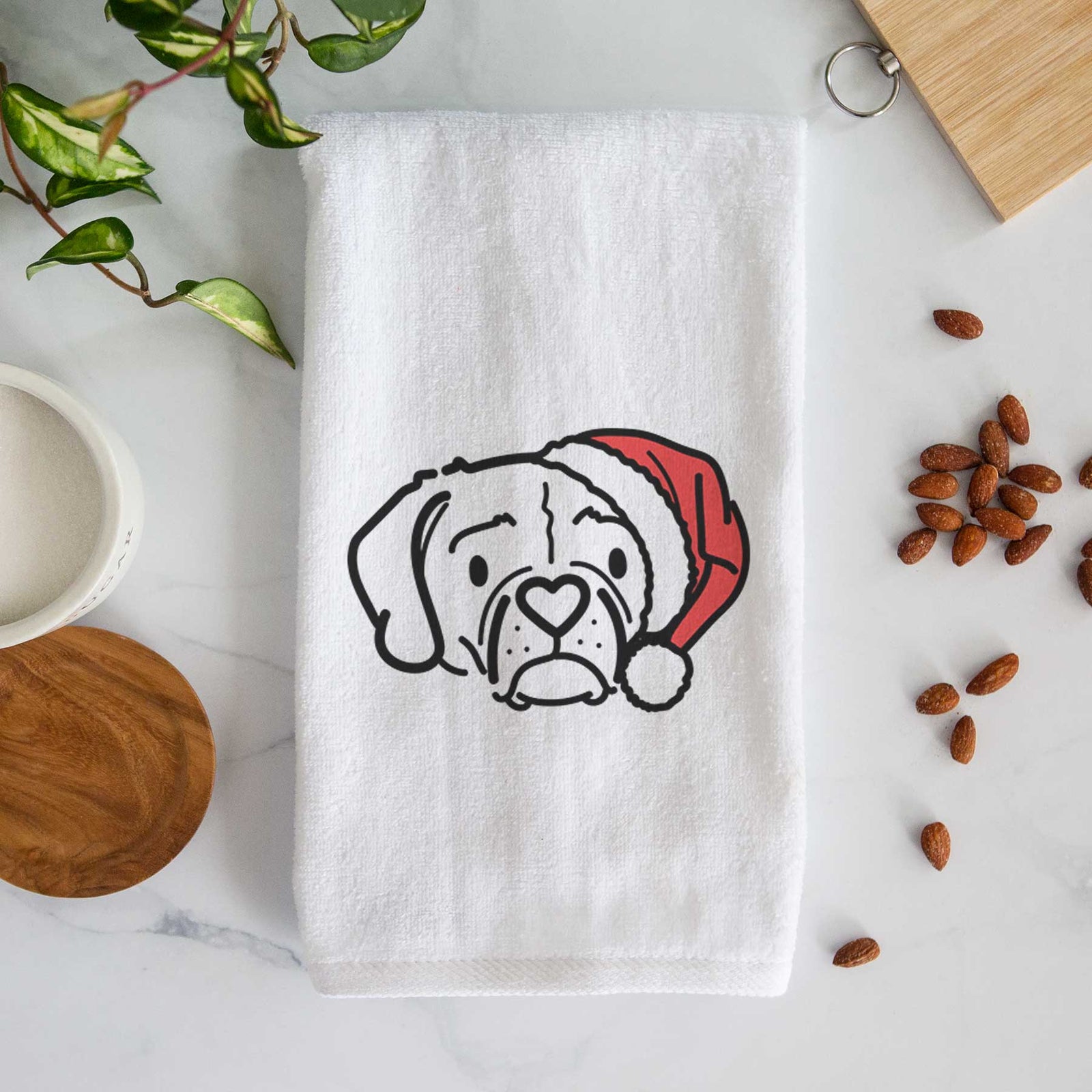 Minimalist line drawing of Mitzi the Puggle wearing a Santa hat on a decorative hand towel