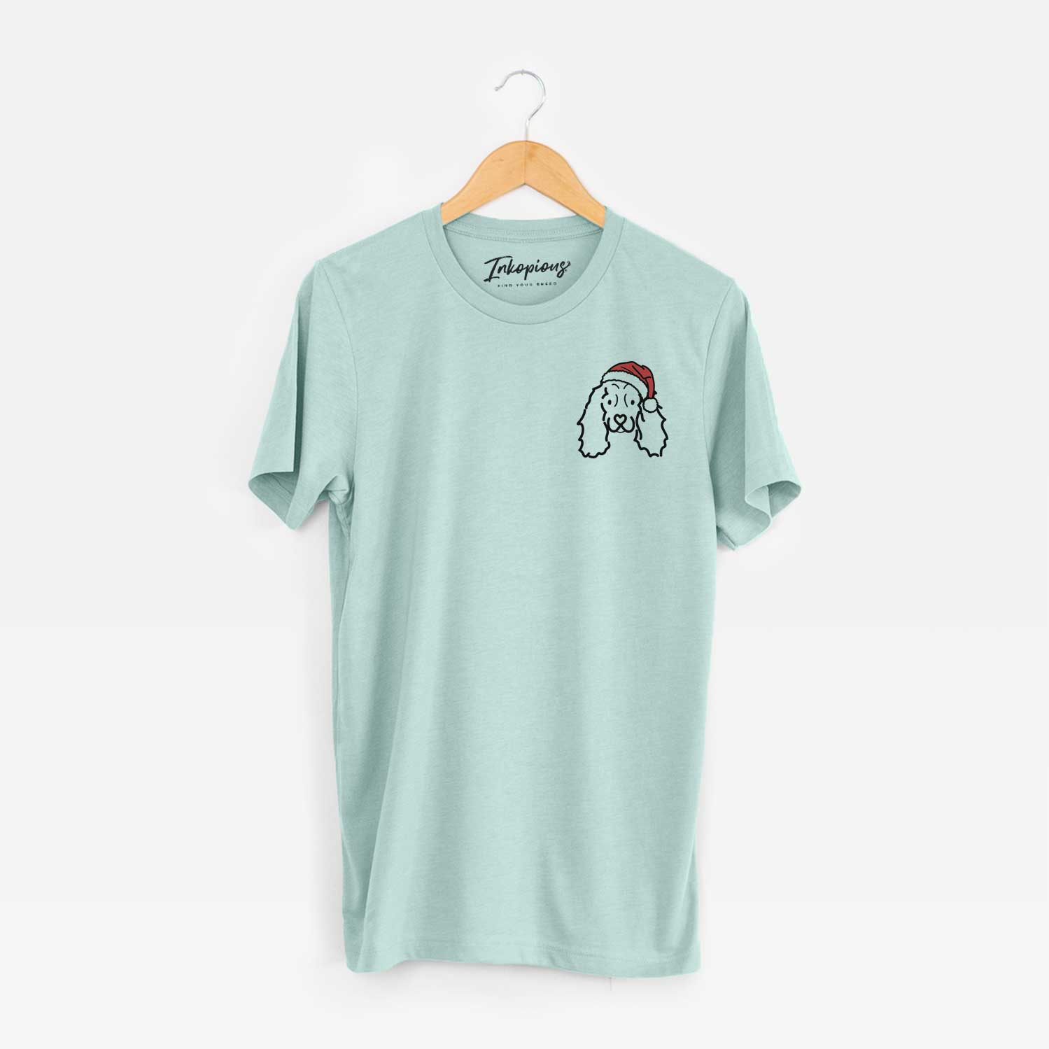 Small chest-pocket minimalist line drawing of an American Cocker Spaniel wearing a Santa hat on a Heather Sage Unisex crewneck